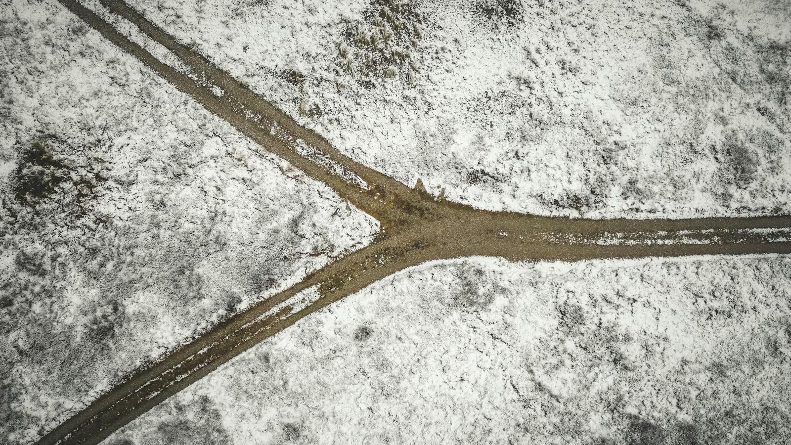 Aerial photo of a snowy landscape with a forked dirt road near Bindslev in northern Denmark.
