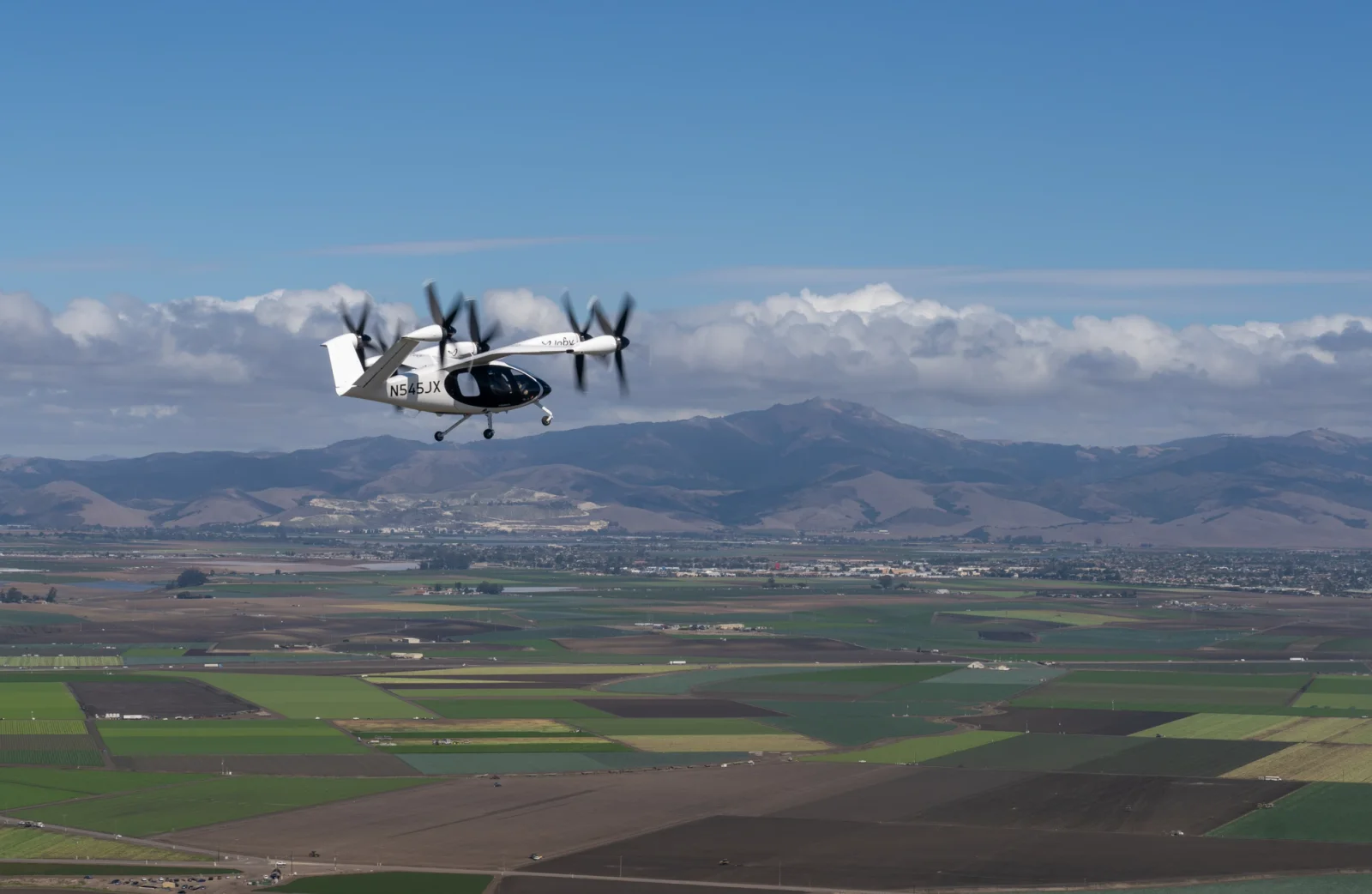 Joby’s aircraft flying over Monterey, California with Salinas in the background.