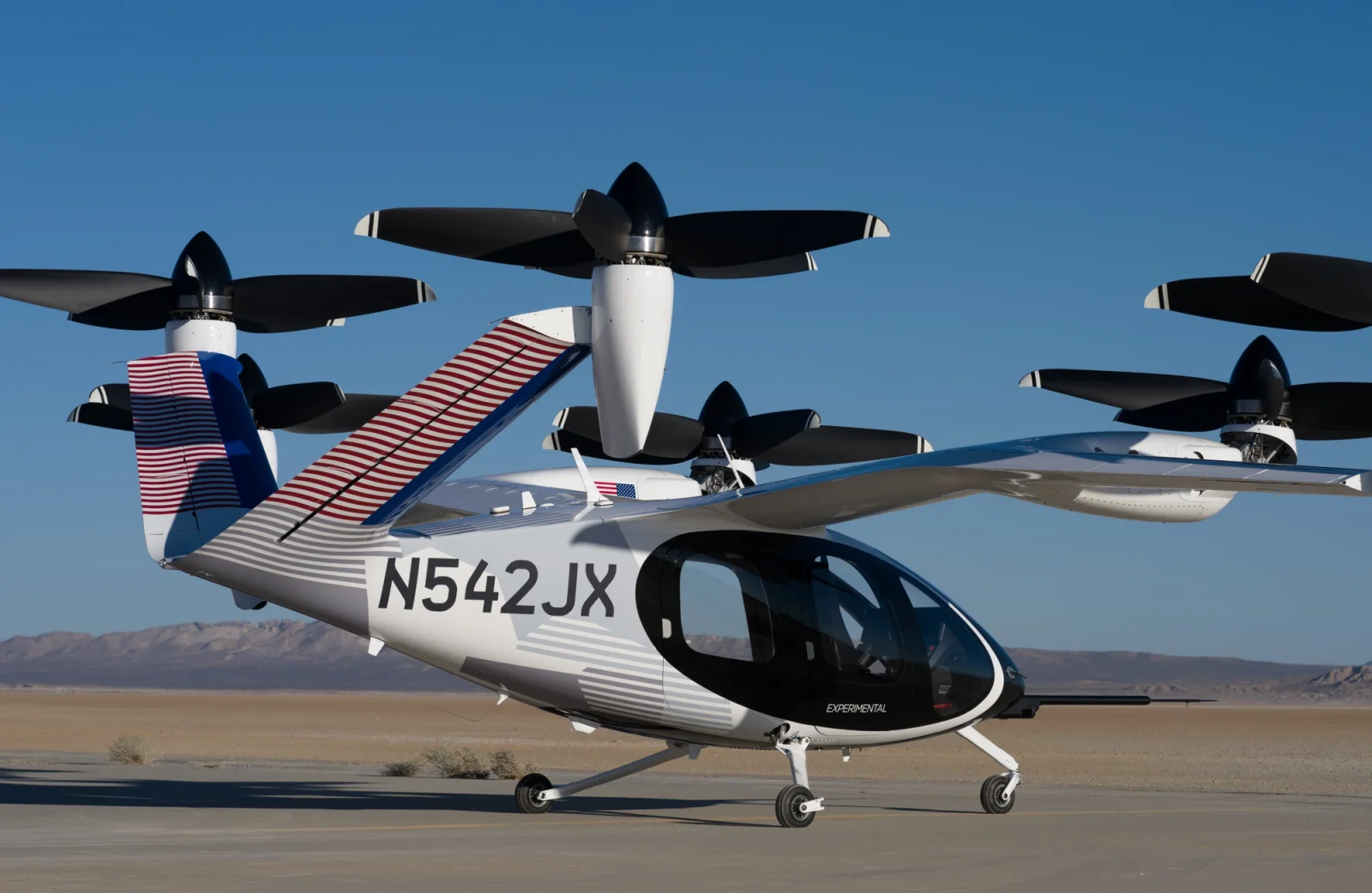A side view of a Joby electric taxi with a red, white, and blue livery.