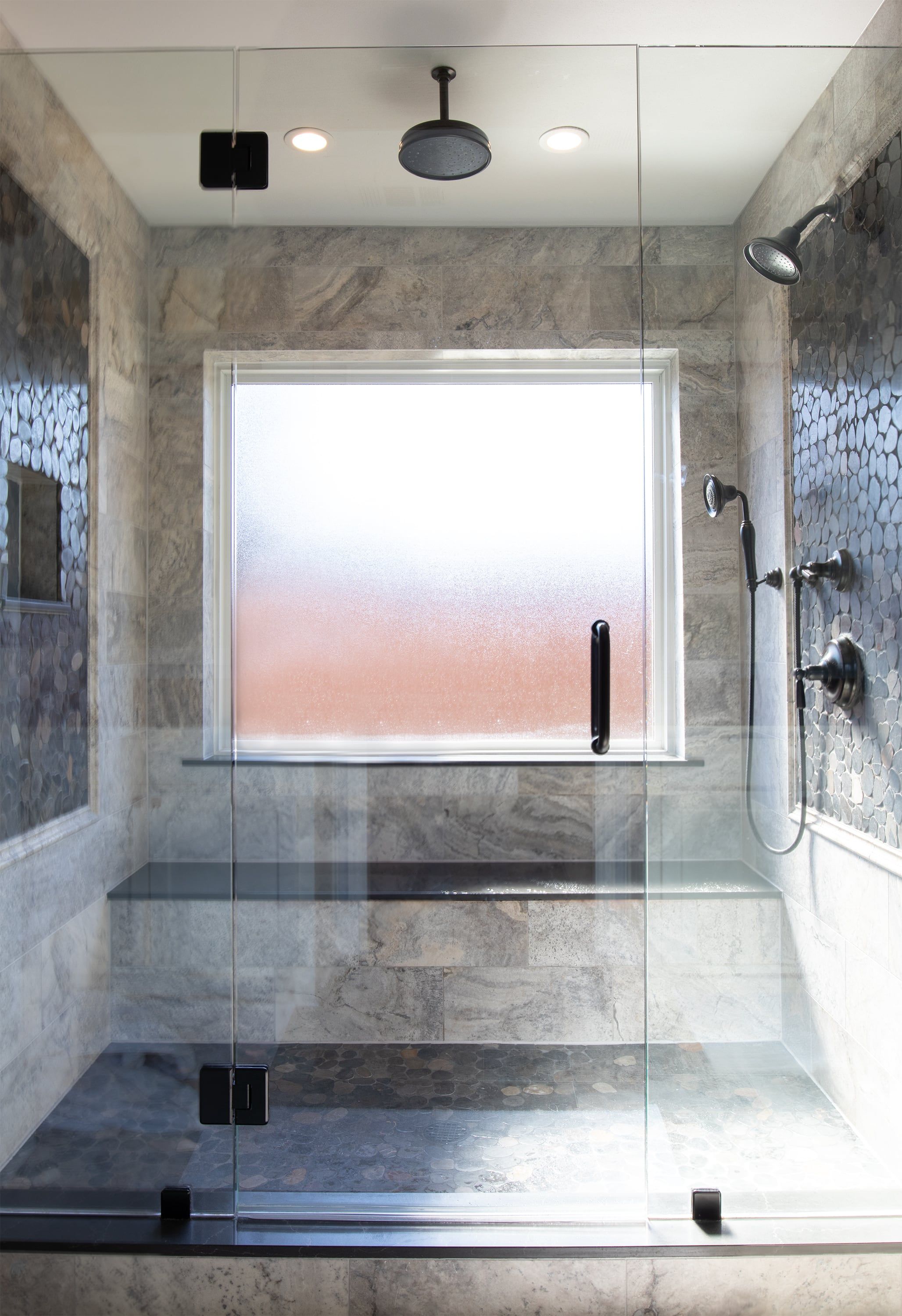 Walk-in shower with a glass enclosure, stone tile walls, a bench and a rain head