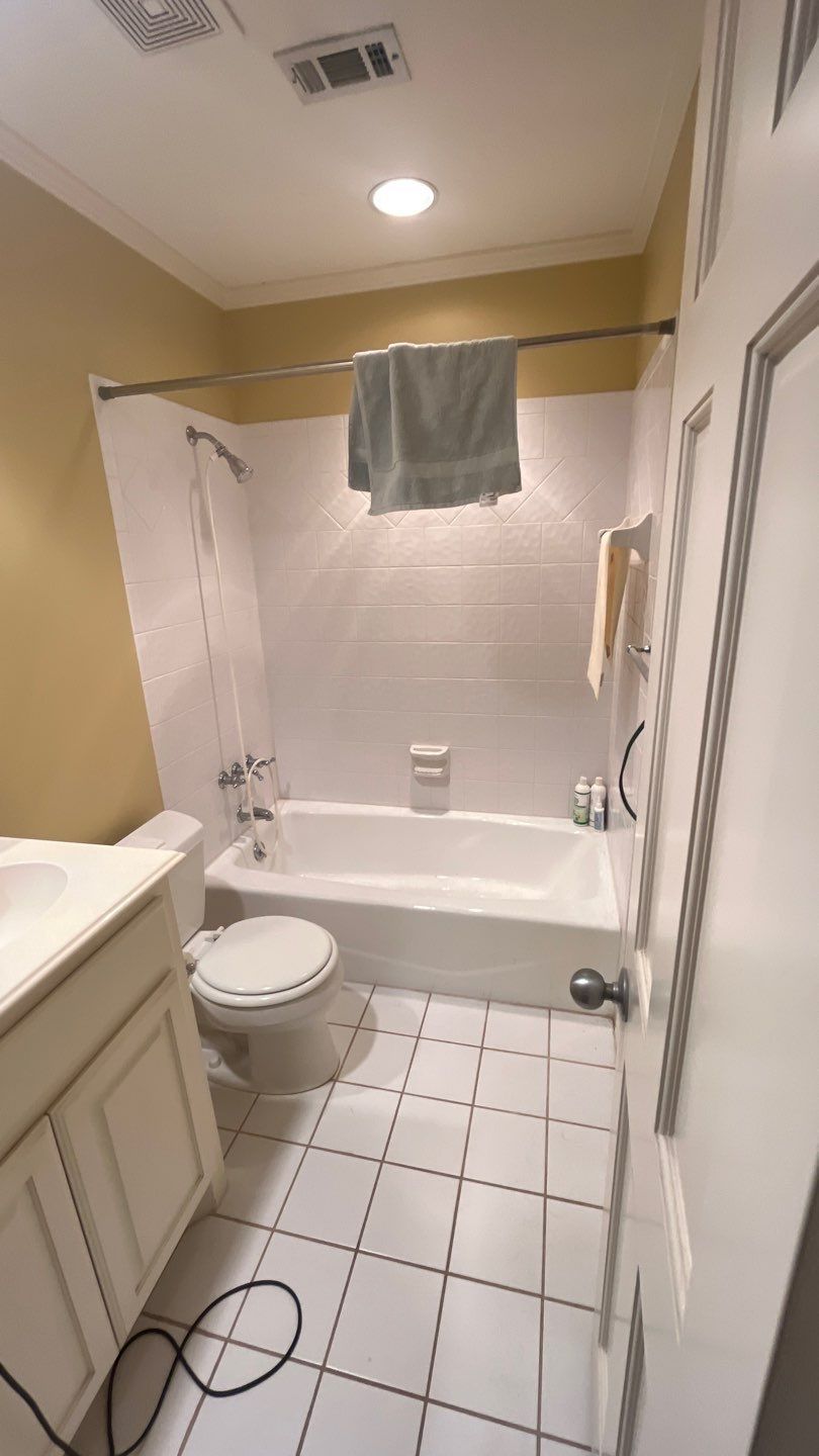 Jack-and-Jill bath before: a tub with a shower curtain and white tile