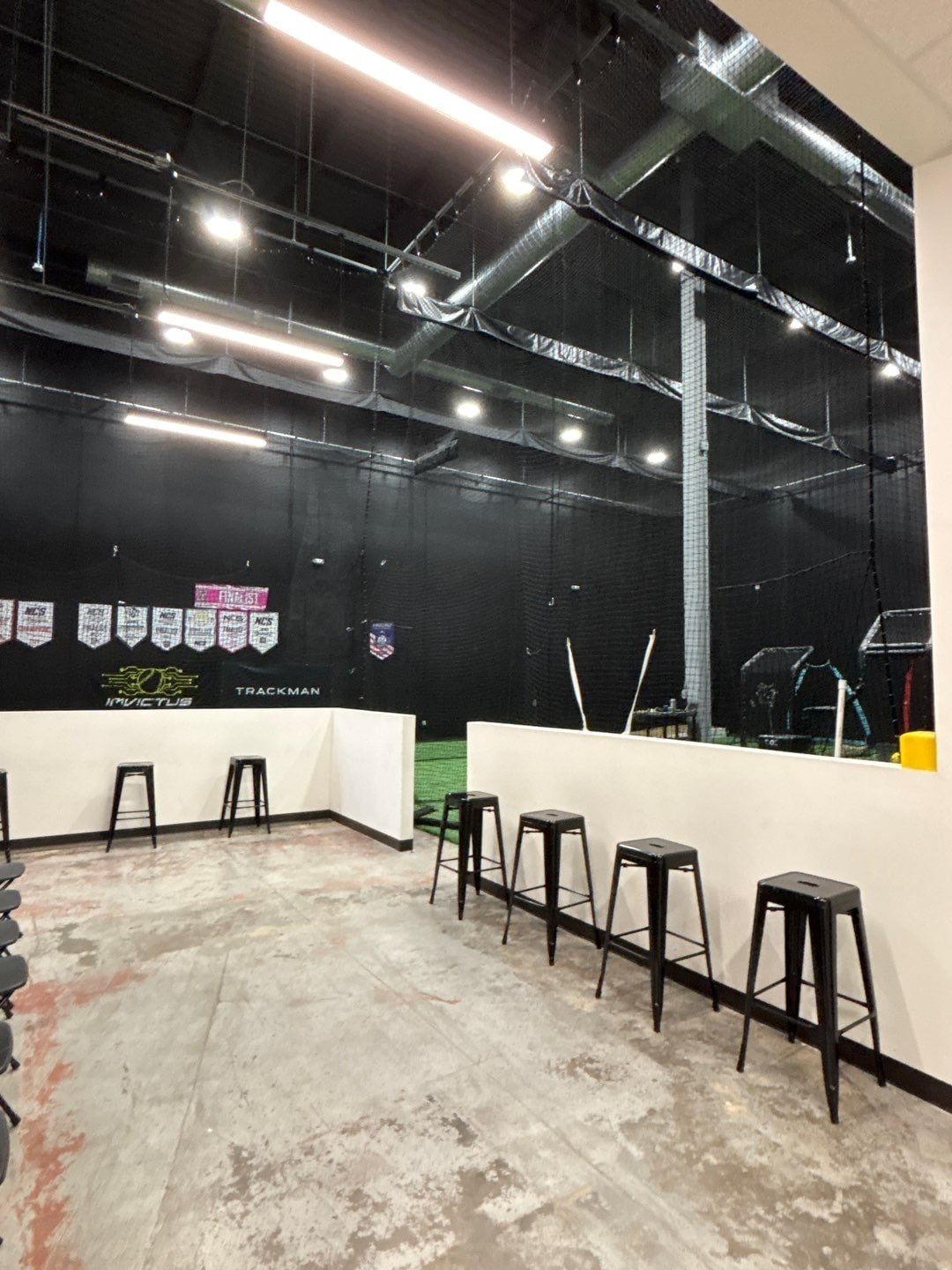 Commercial lounge with turf flooring and an exposed black ceiling