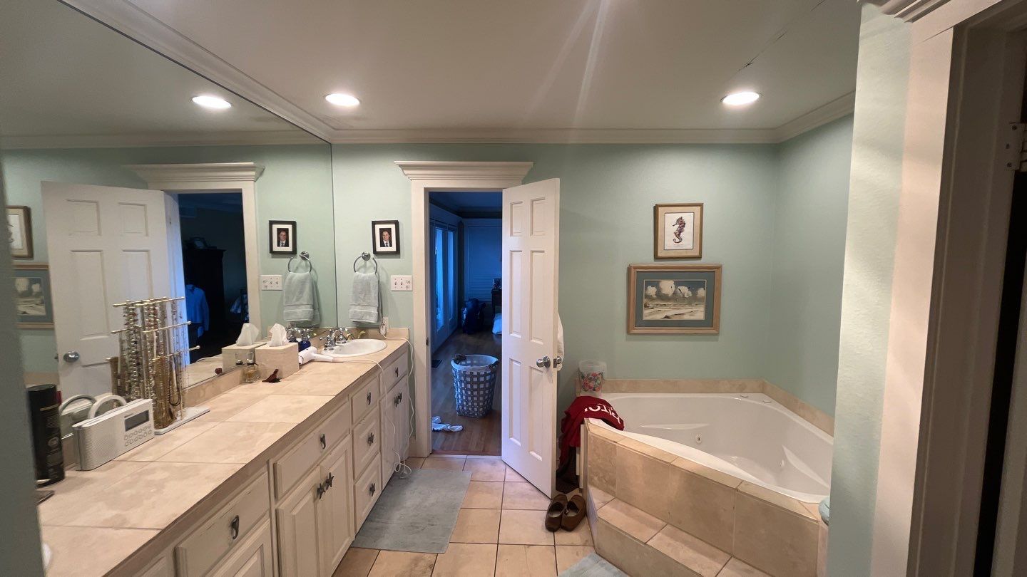Primary bath before: a long vanity, a corner tub and tile floors