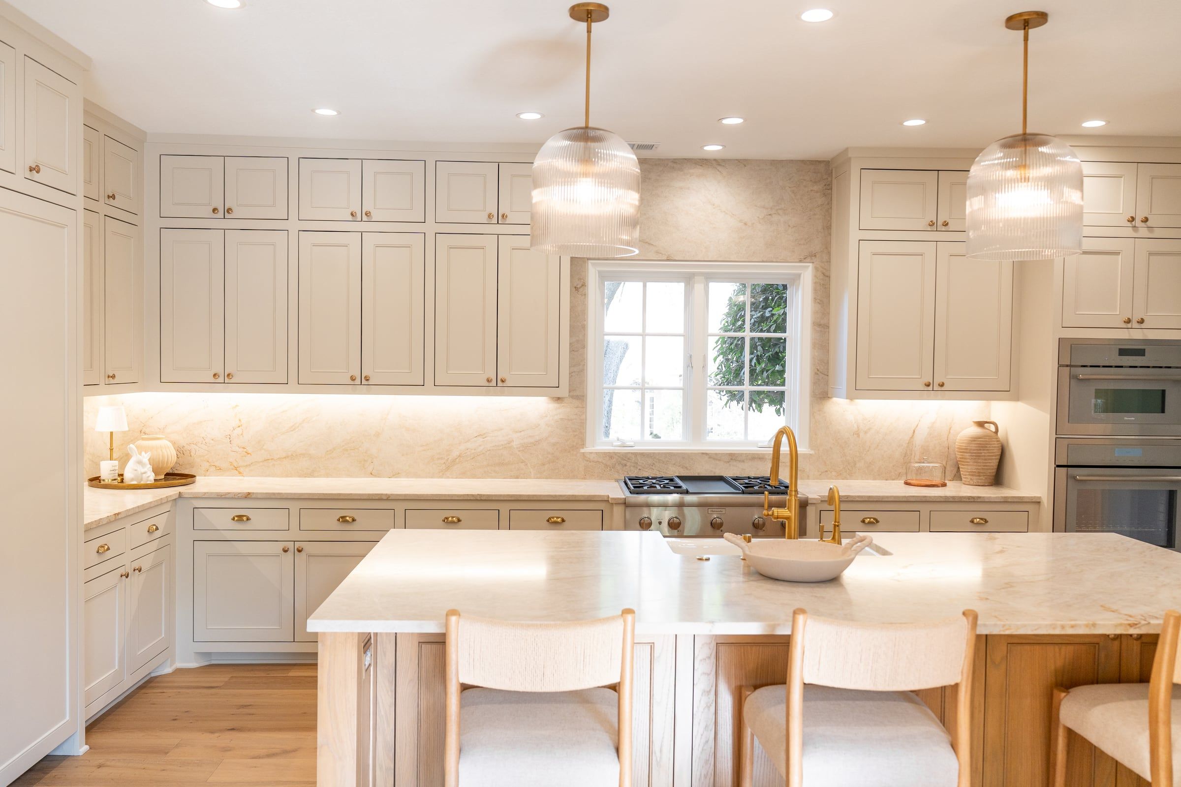 Renovated kitchen with a marble island and panelled cabinetry