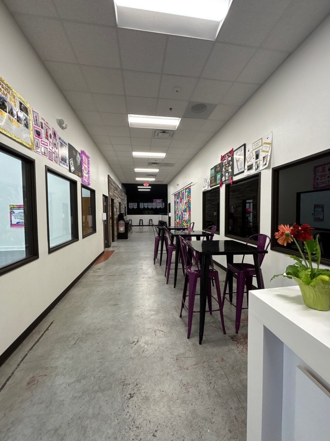 Hallway of the athletic facility with viewing windows and high-top tables