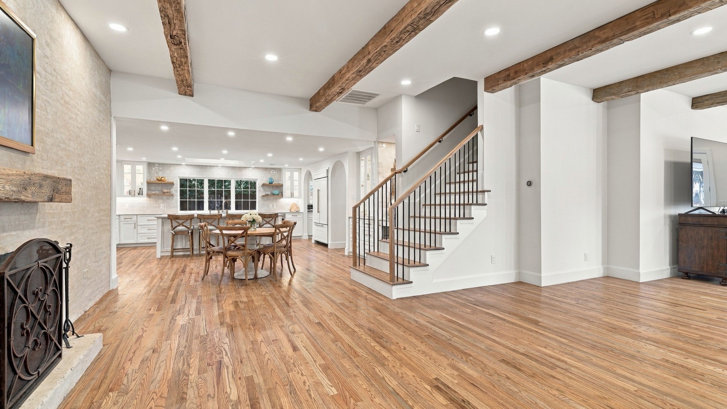 Living room after: oak floors, wood beams and a stone fireplace wall