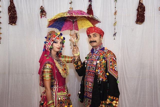 A man and a woman in traditional Garba dance outfits