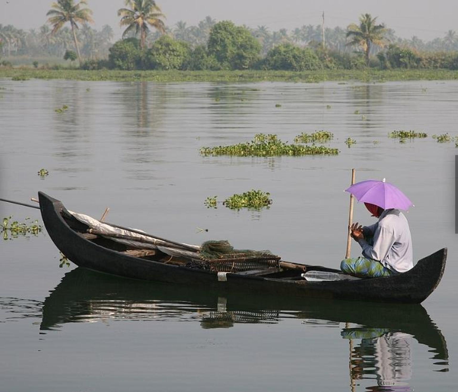 A fisherman paddling a boat 