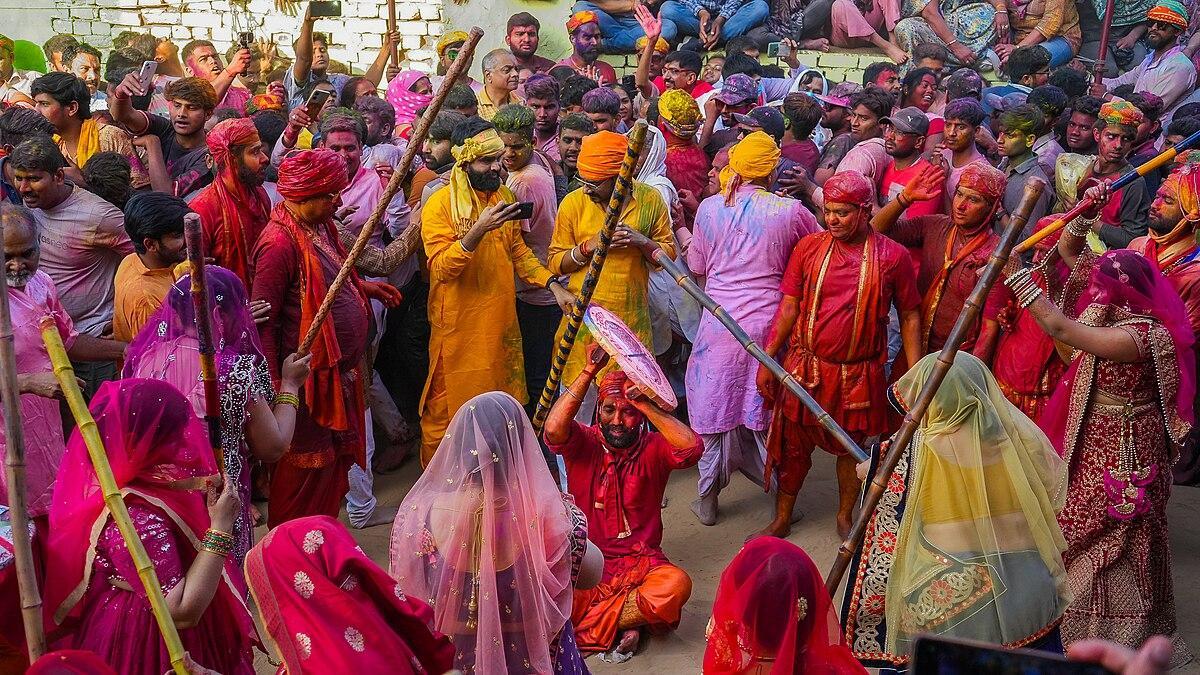 Crowd celebrates Holi as women beat men with sticks