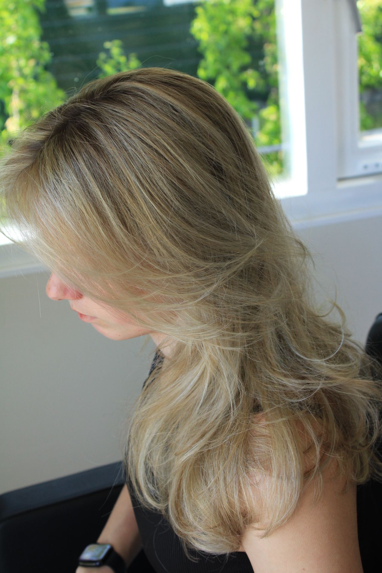 blonde vrouw met krullen in kapperstoel
