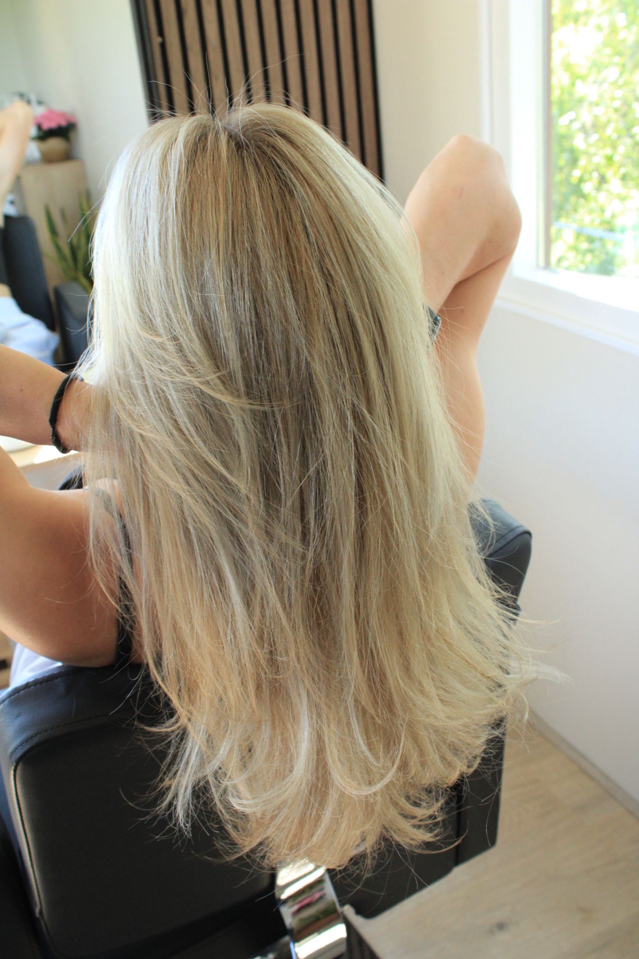 blonde vrouw met krullen in kapperstoel