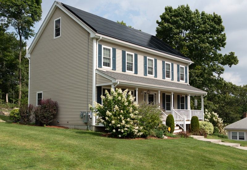 Large white house with solar panels on the roof
