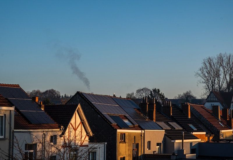 A row of homes against a blue sky with solar panels