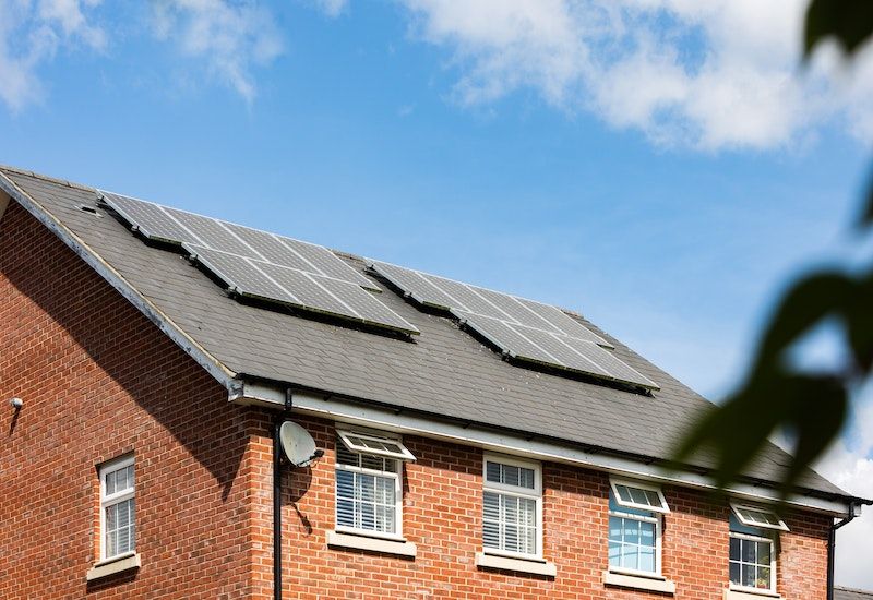 A tan house with solar panels on the roof