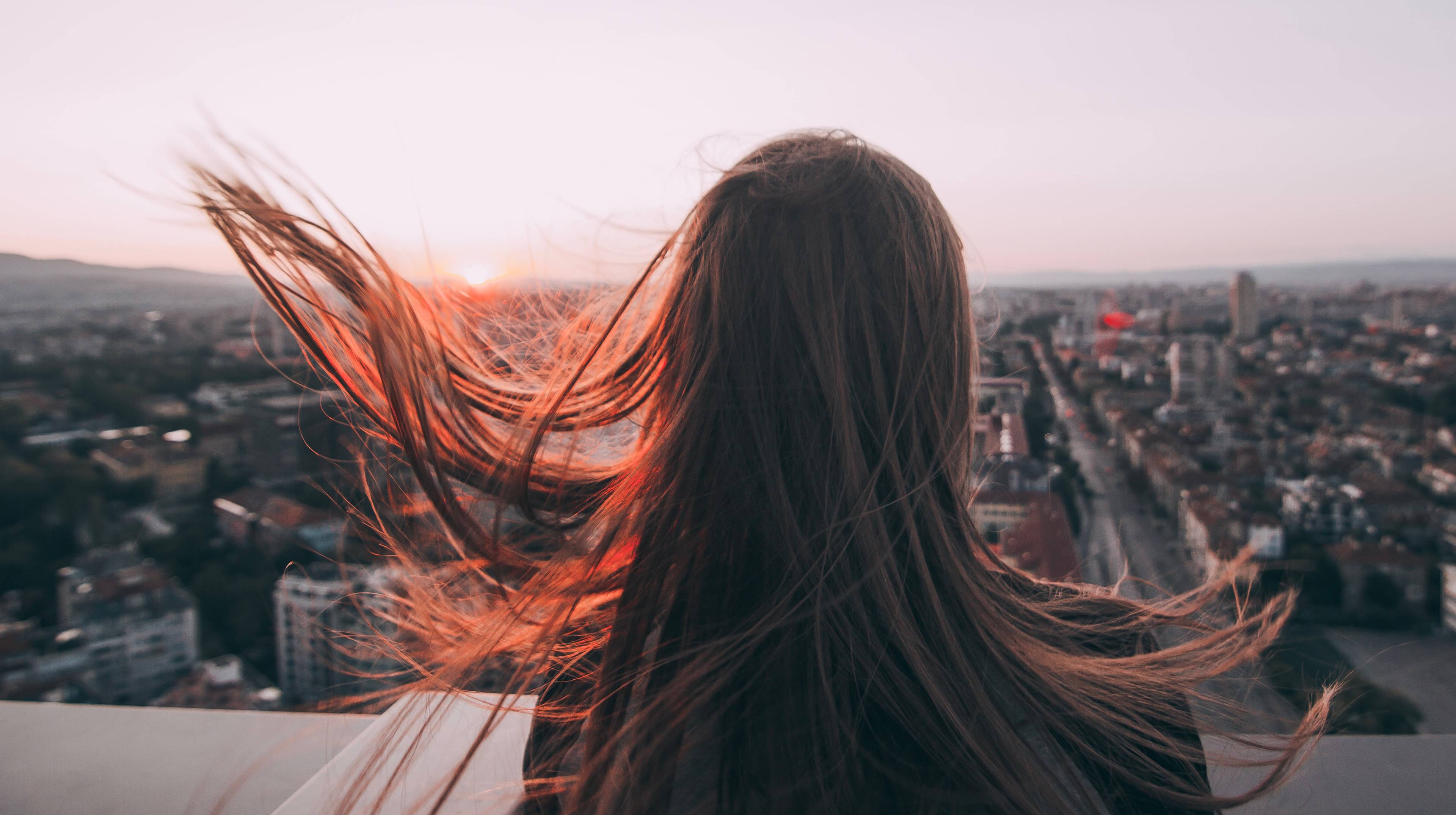 Woman overlooking a city at sunset