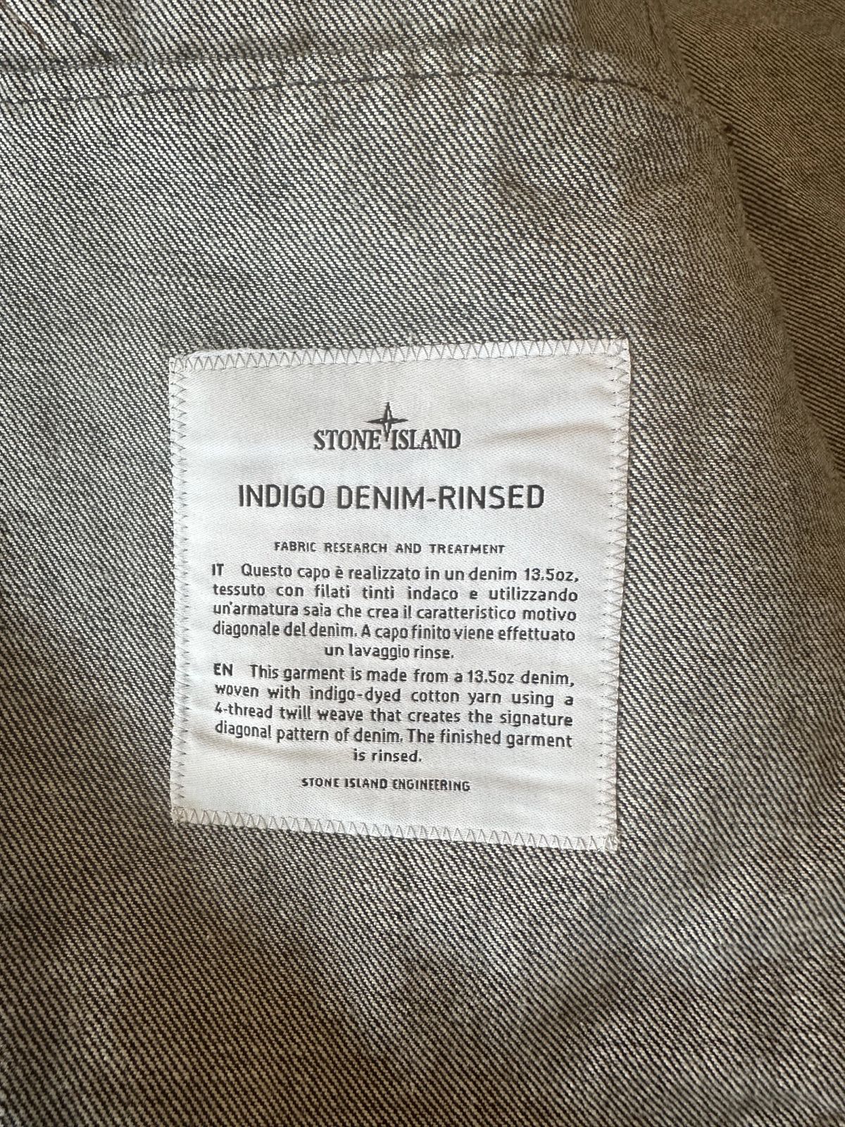 Het ingestikte Stone Island-label met het kopje Fabric Research and Treatment en de tekst Stone Island Engineering