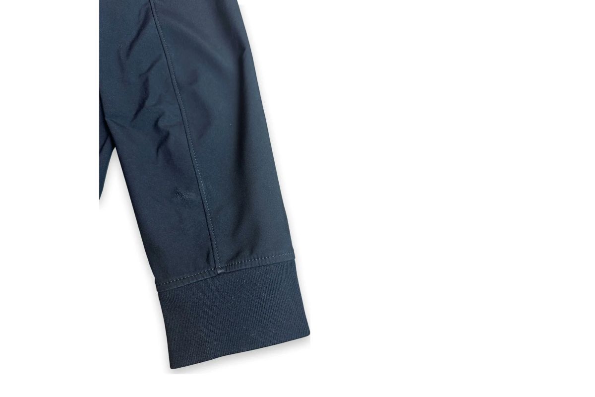 A small snag near the cuff of a preloved Stone Island Light Soft Shell-R jacket, sleeve detail