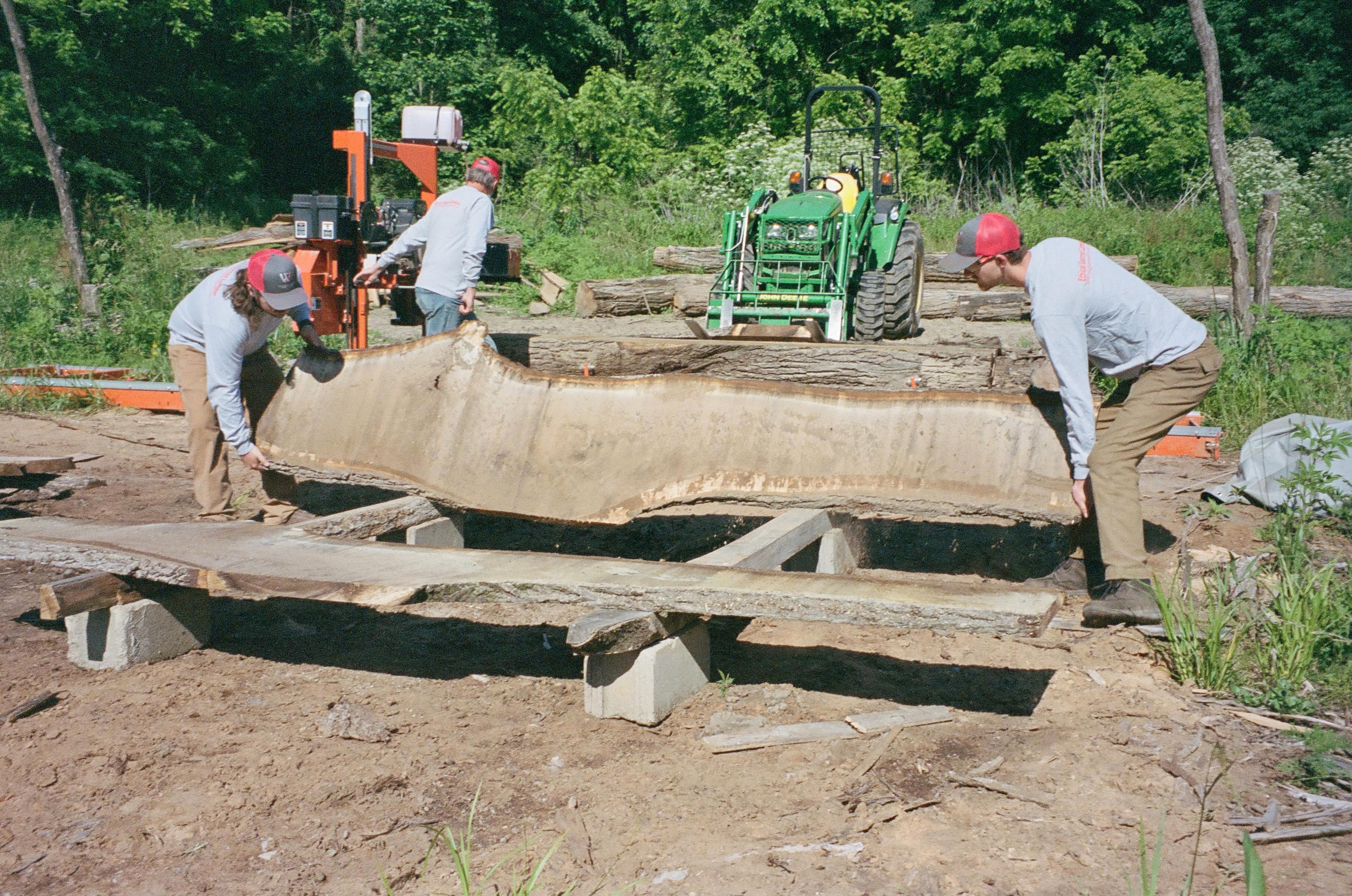The WhiteWater Ranch crew lifts wood to cut. 
