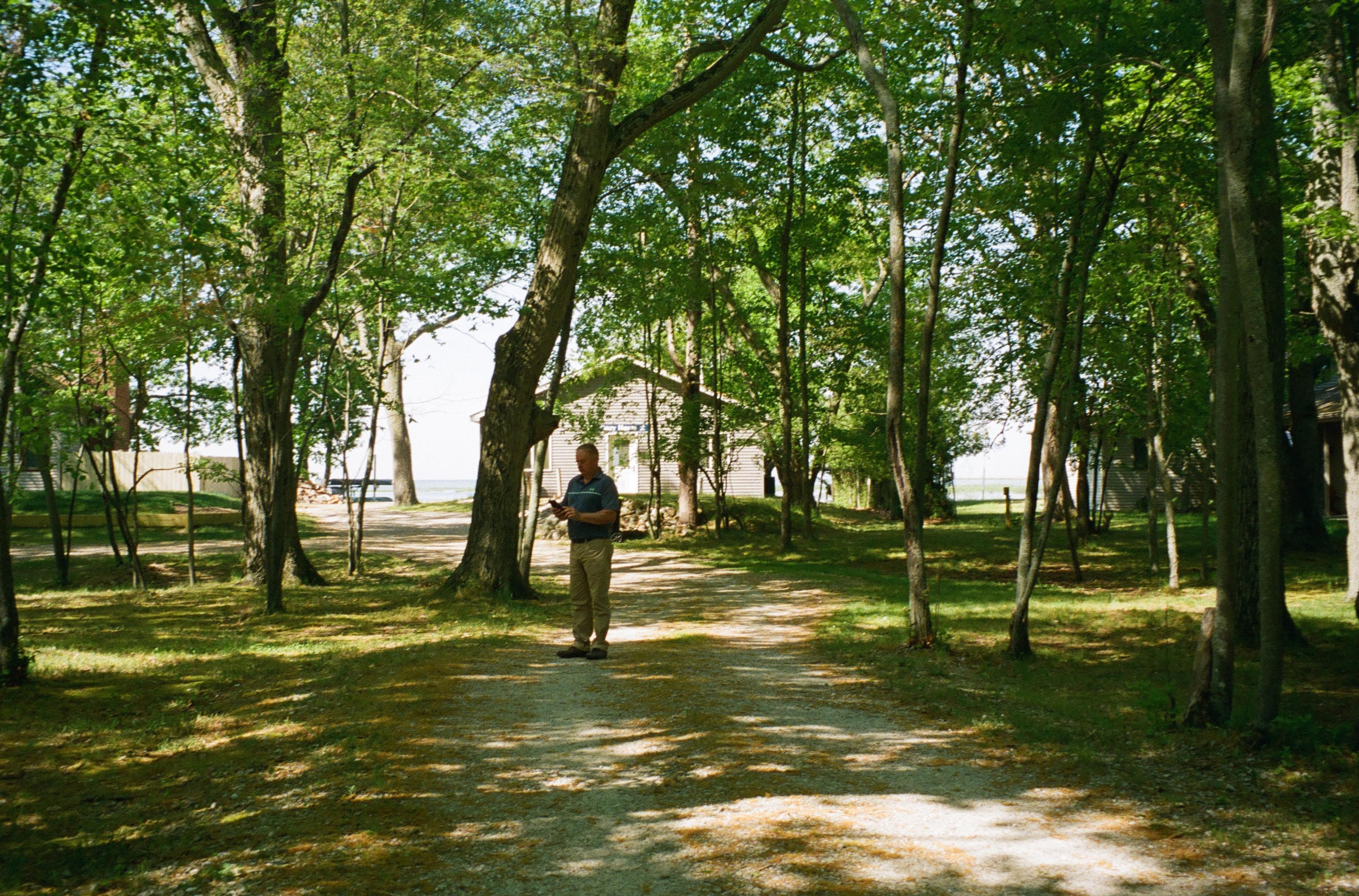 On a path near his property, Jeff checks work on his phone.