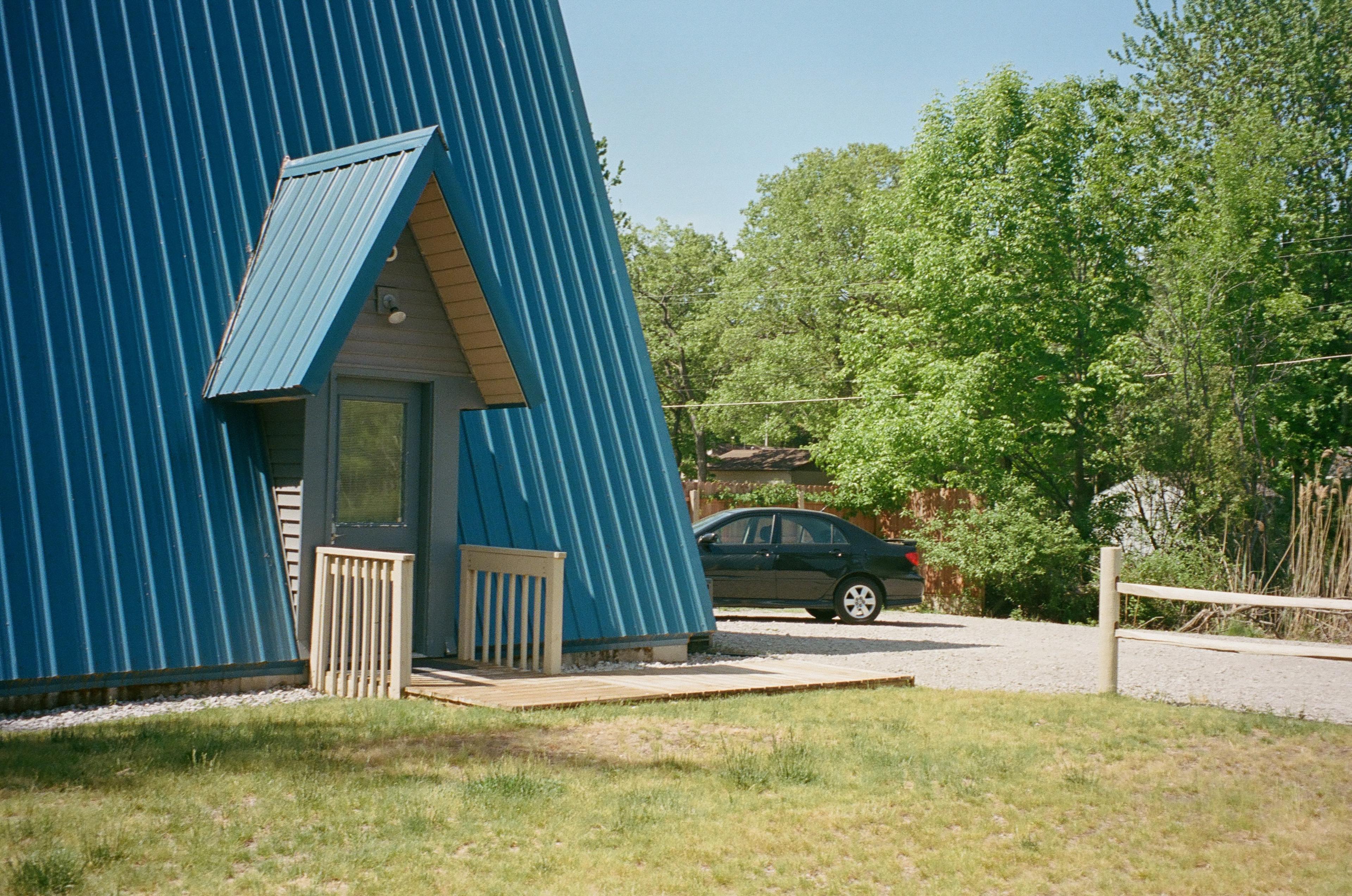 The door to one of Jeff's cabins, with a bright blue A-frame roof.
