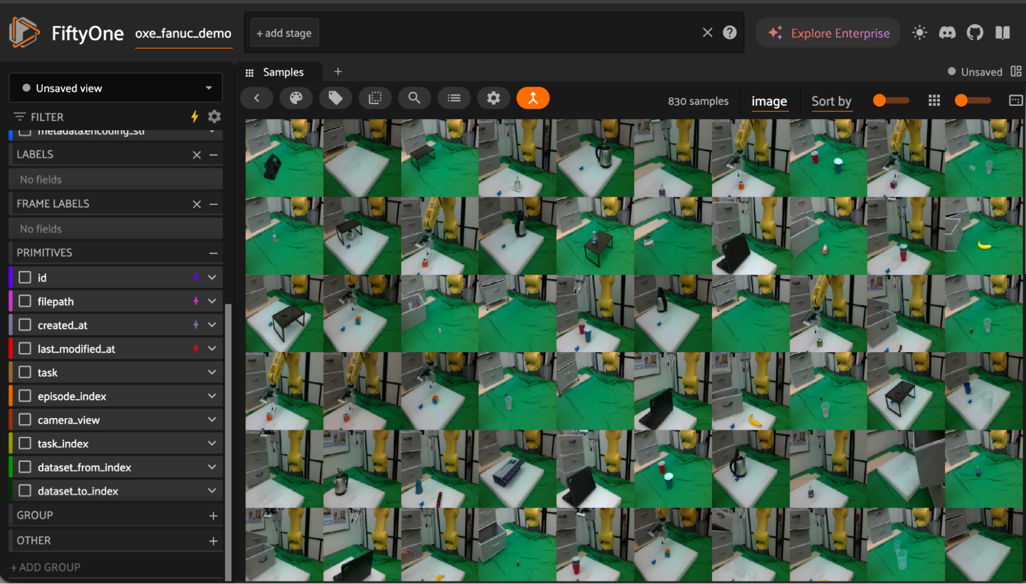 FiftyOne app showing the oxe_fanuc_demo dataset as a grid of 830 robot manipulation samples, with a yellow FANUC arm above a green work surface and the sidebar listing task, episode_index, and camera_view fields.