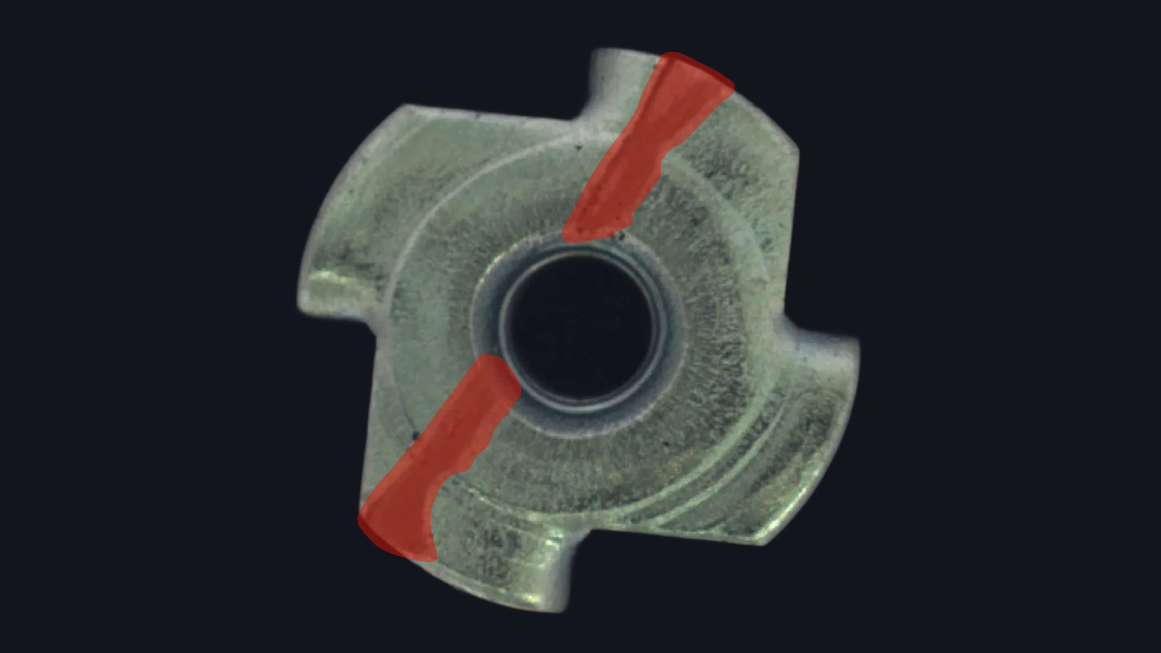 Close-up of a metal industrial part with two red-highlighted defect regions marking surface cracks.