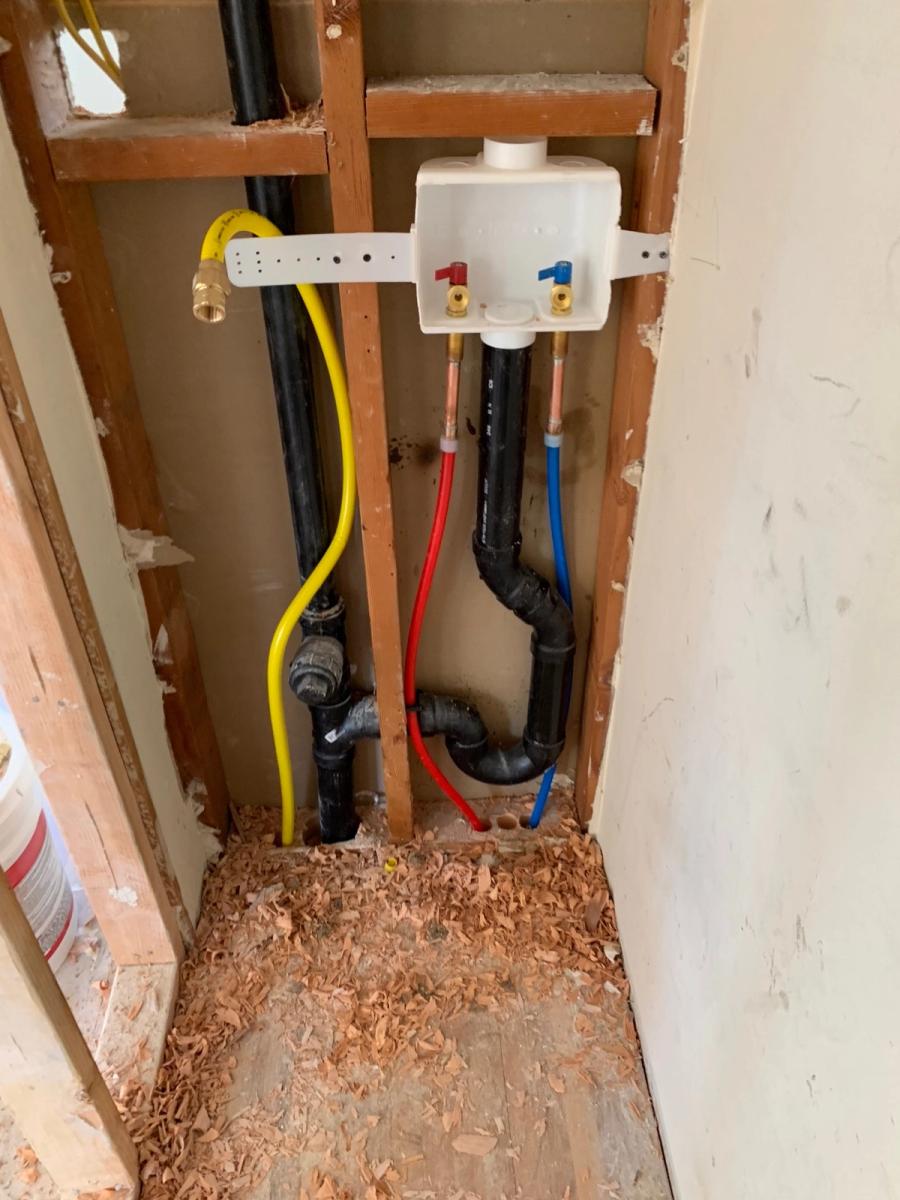 Rough plumbing installation with PEX piping in a wall during remodel