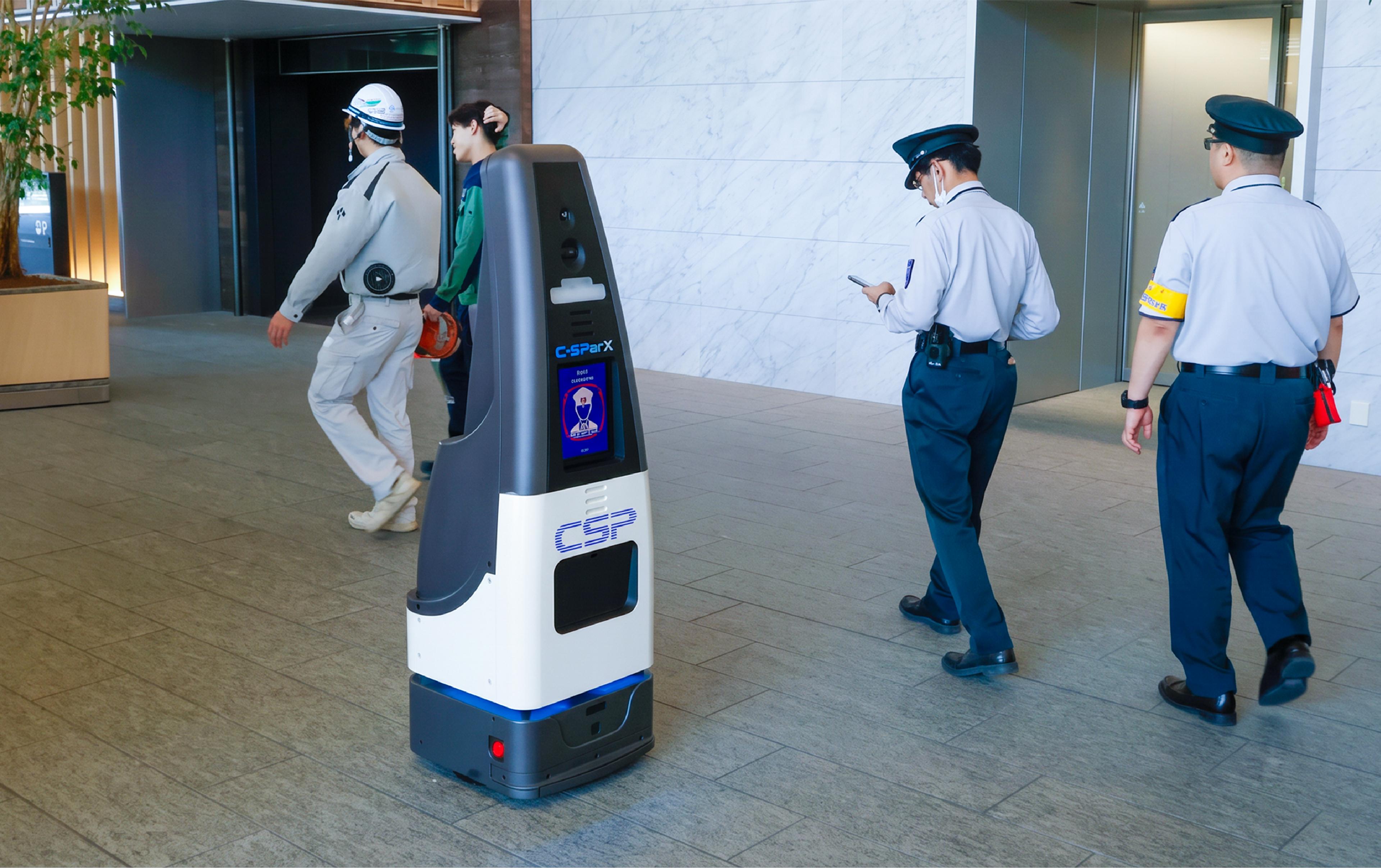 CSP-branded security patrol robot with a display screen moving through an office lobby as two uniformed guards and a worker pass by
