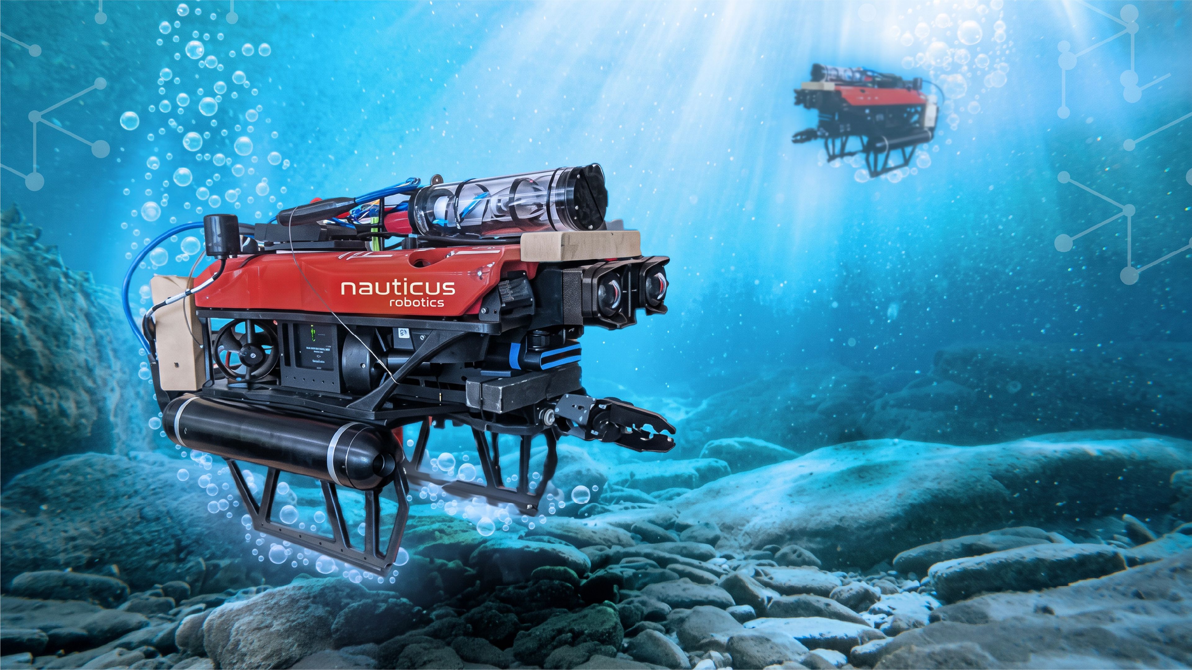 Nauticus Robotics subsea robot equipped with cameras and a manipulator arm operating underwater above a rocky seafloor.