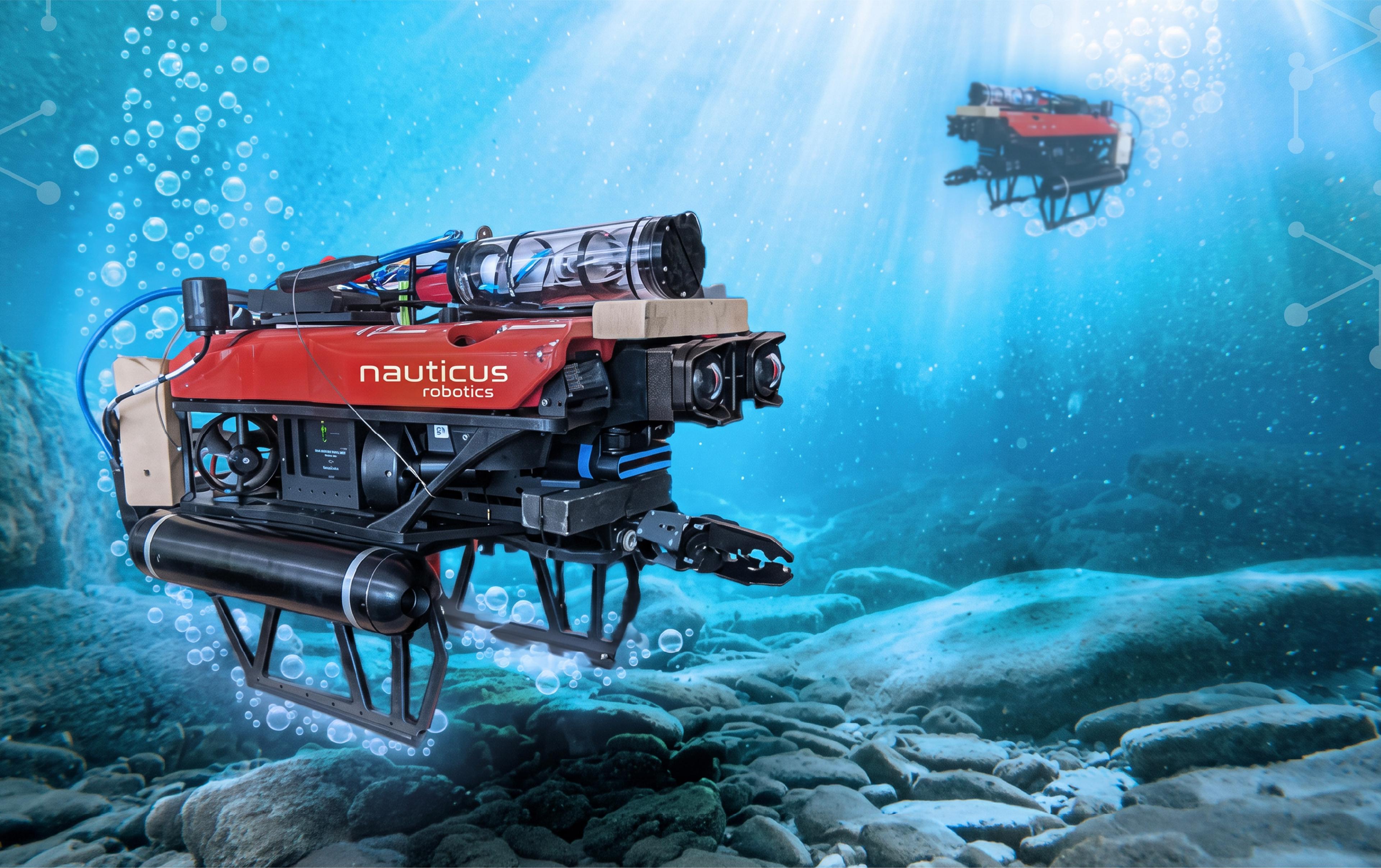 Nauticus Robotics subsea robot equipped with cameras and a manipulator arm operating underwater above a rocky seafloor.