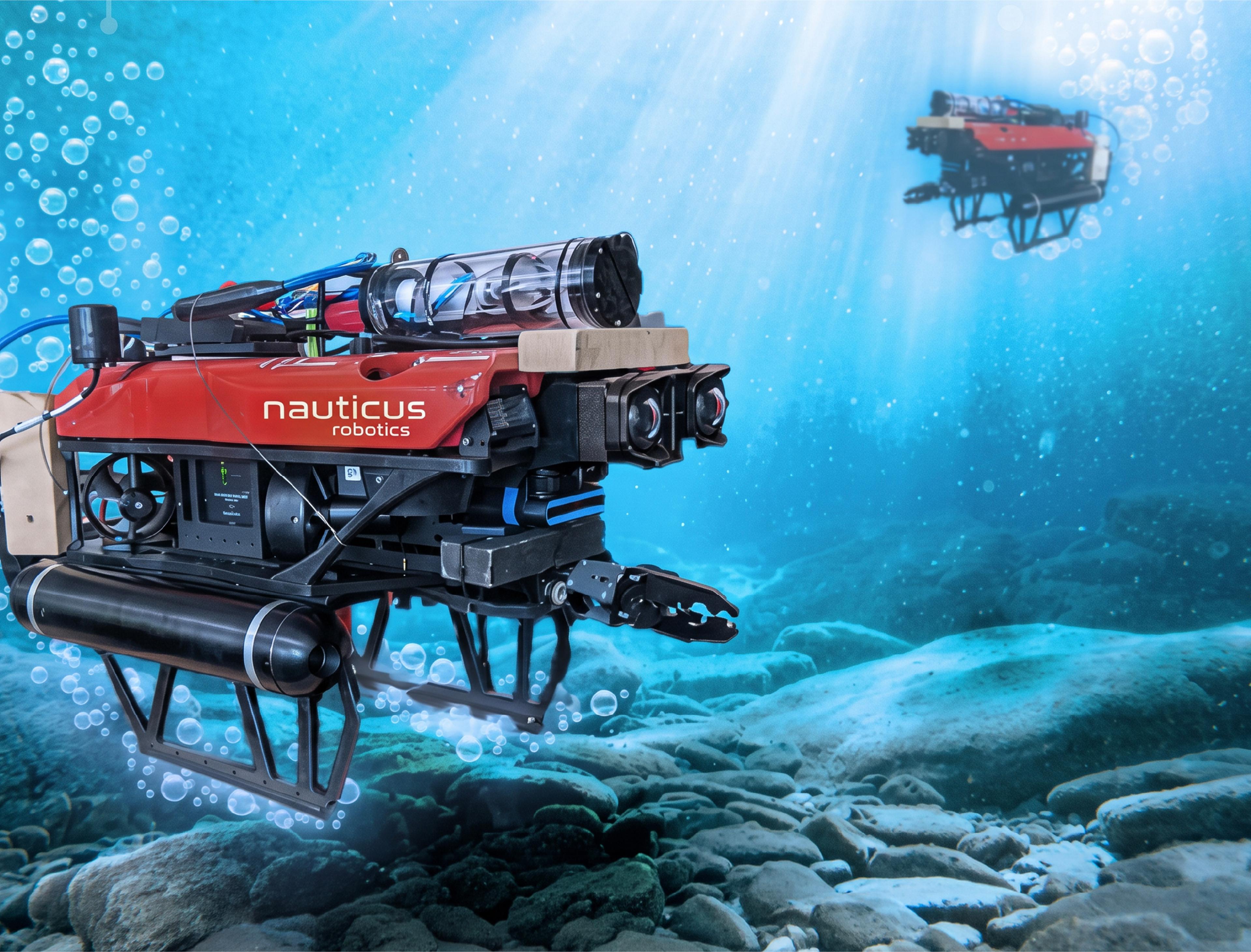 Nauticus Robotics subsea robot equipped with cameras and a manipulator arm operating underwater above a rocky seafloor.