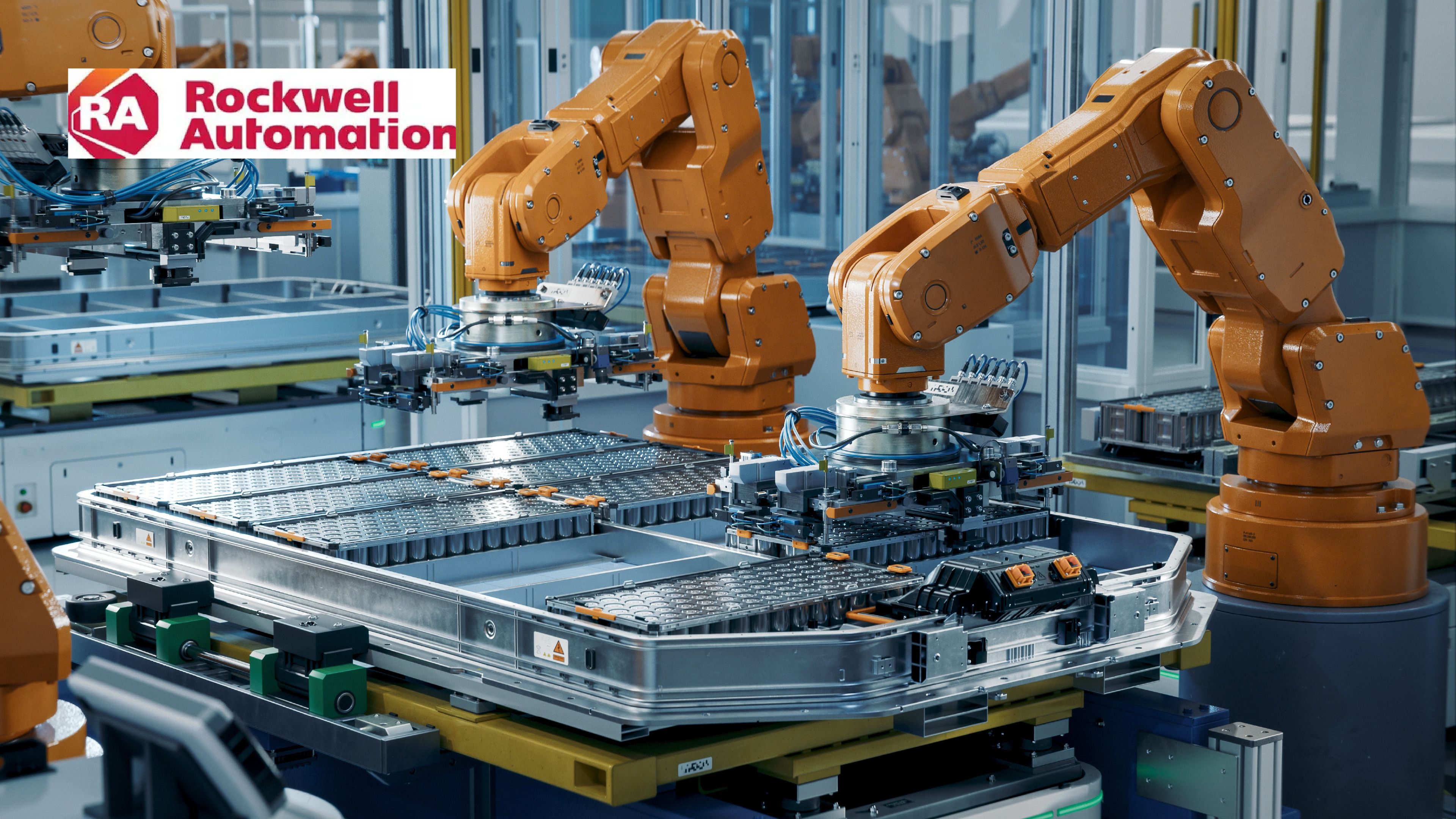 Industrial robotic arms equipped with grippers operate over battery modules.