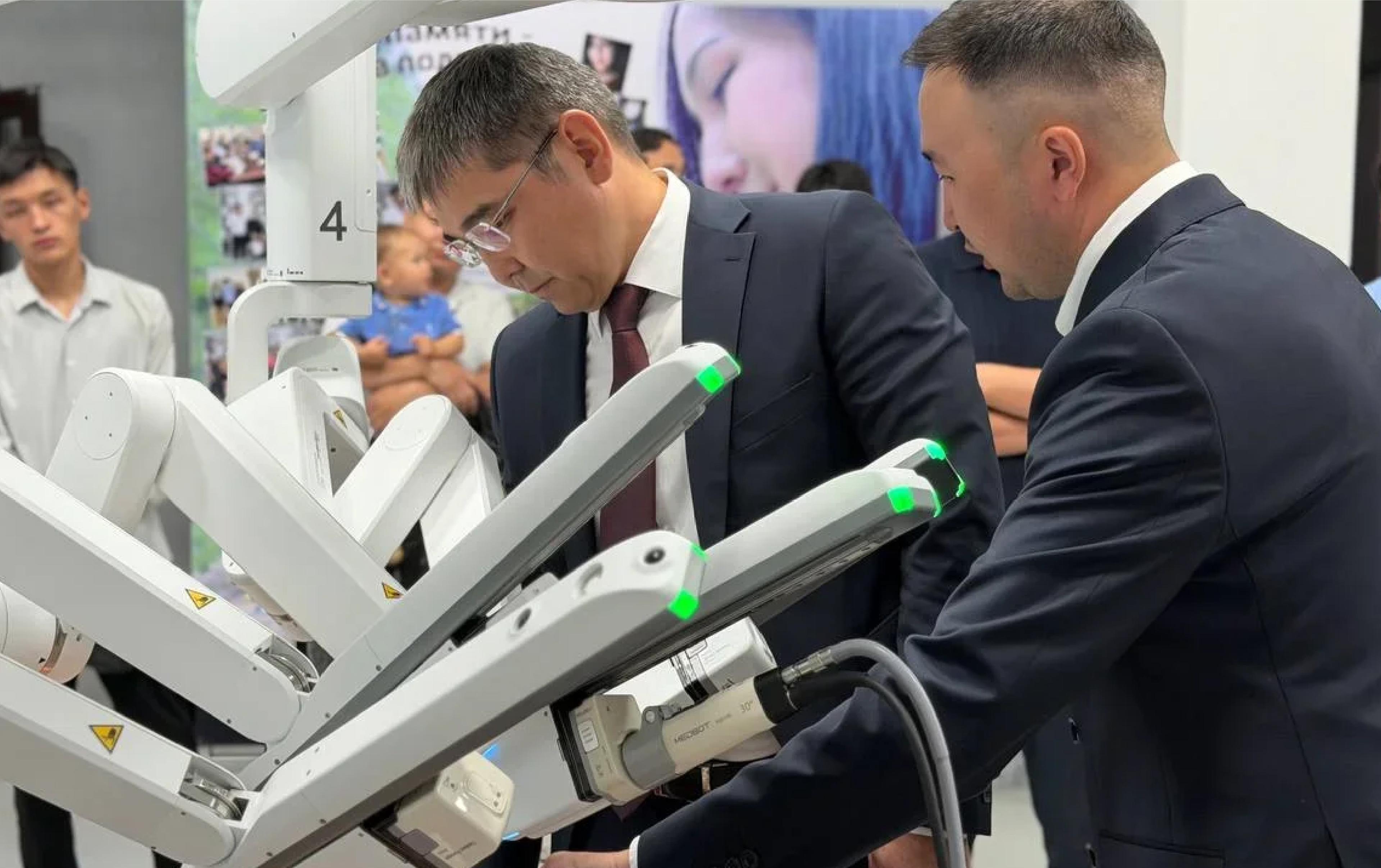 Officials inspect the robotic arms of a MicroPort MedBot Toumai surgical system during its presentation at the Kyrgyz State Medical Academy in Bishkek.