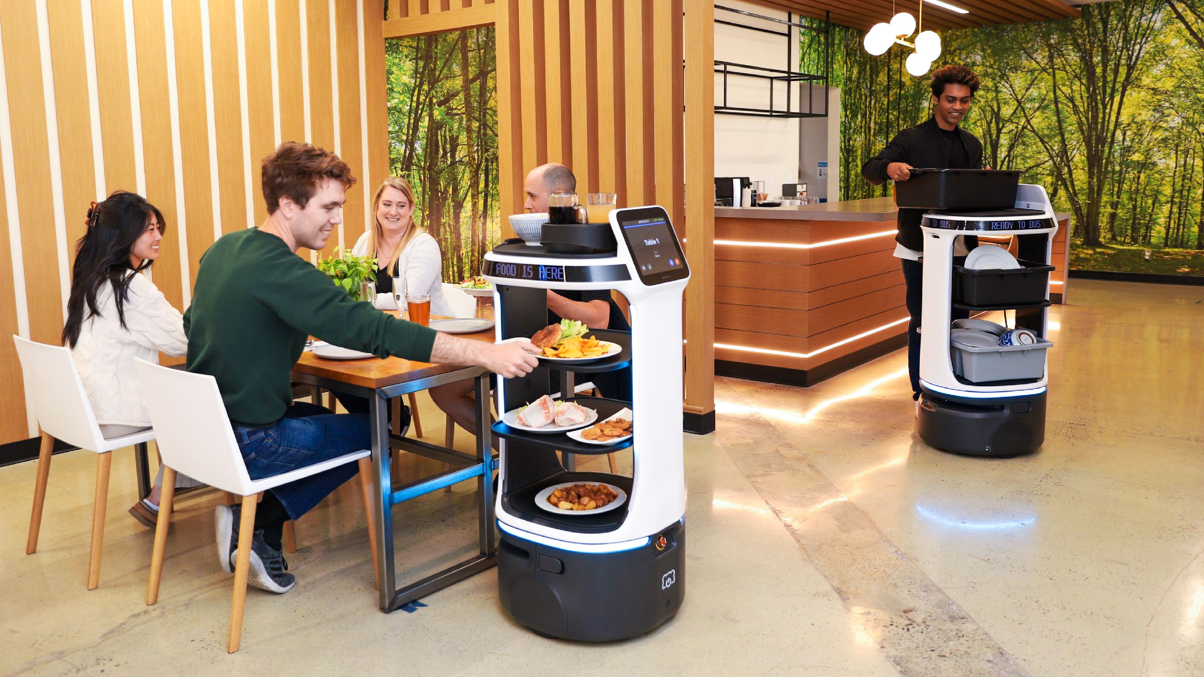 A PUDU BellaBot service robot delivers a meal to a family in a restaurant