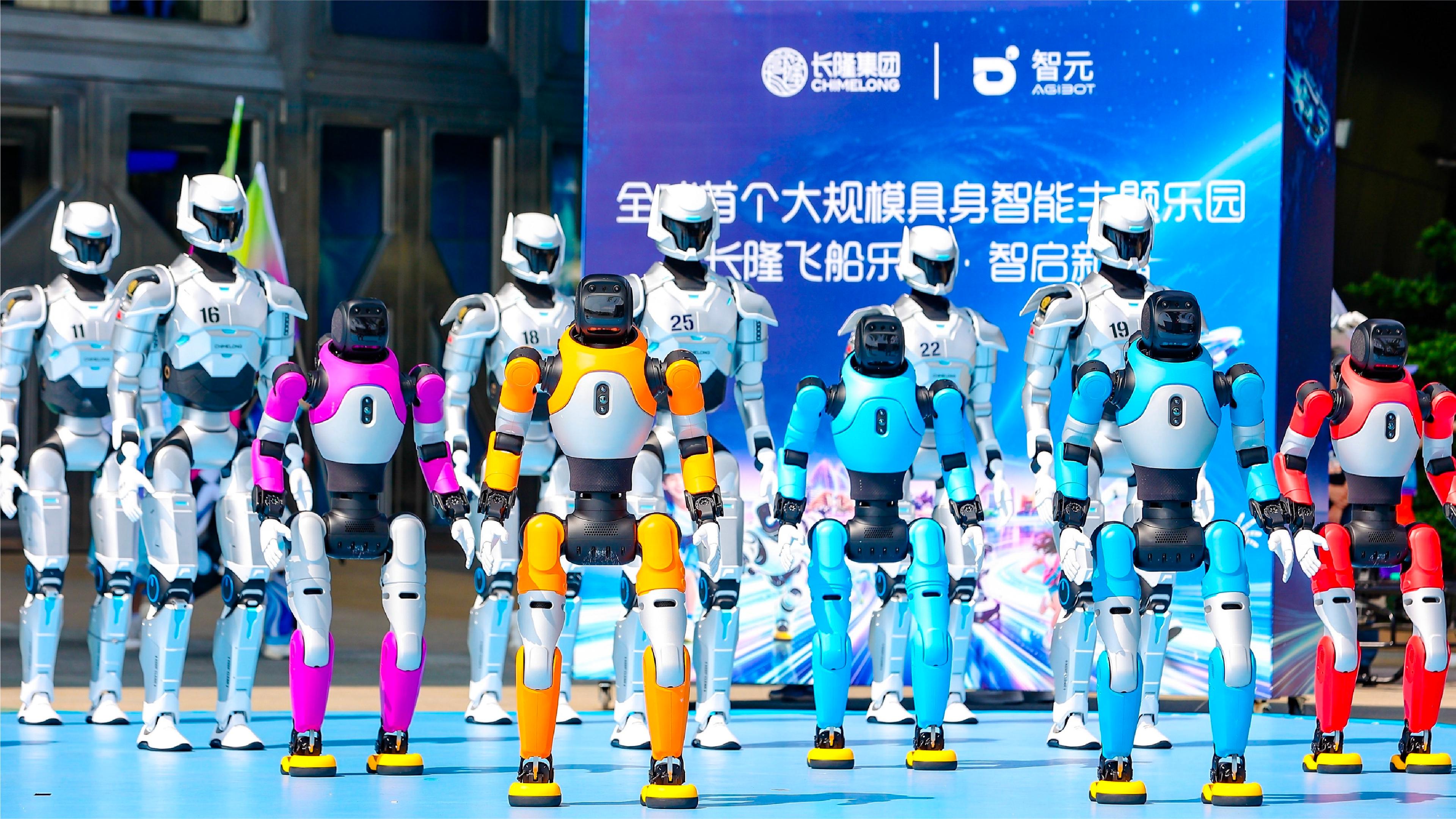 AGIBOT humanoid robots in colorful and white designs stand together during an event at Chimelong Spaceship Park in Zhuhai, China.