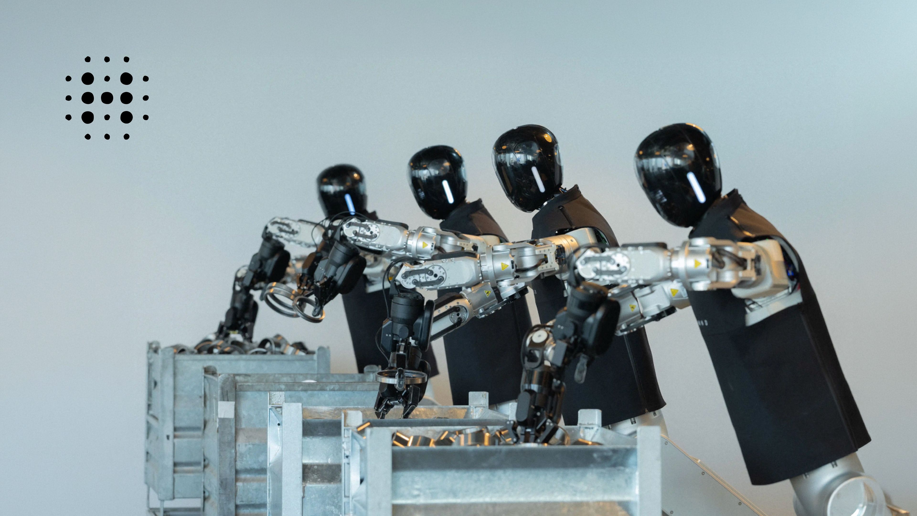 Humanoid-produced robots with articulated arms and grippers handle metal components in industrial bins.
