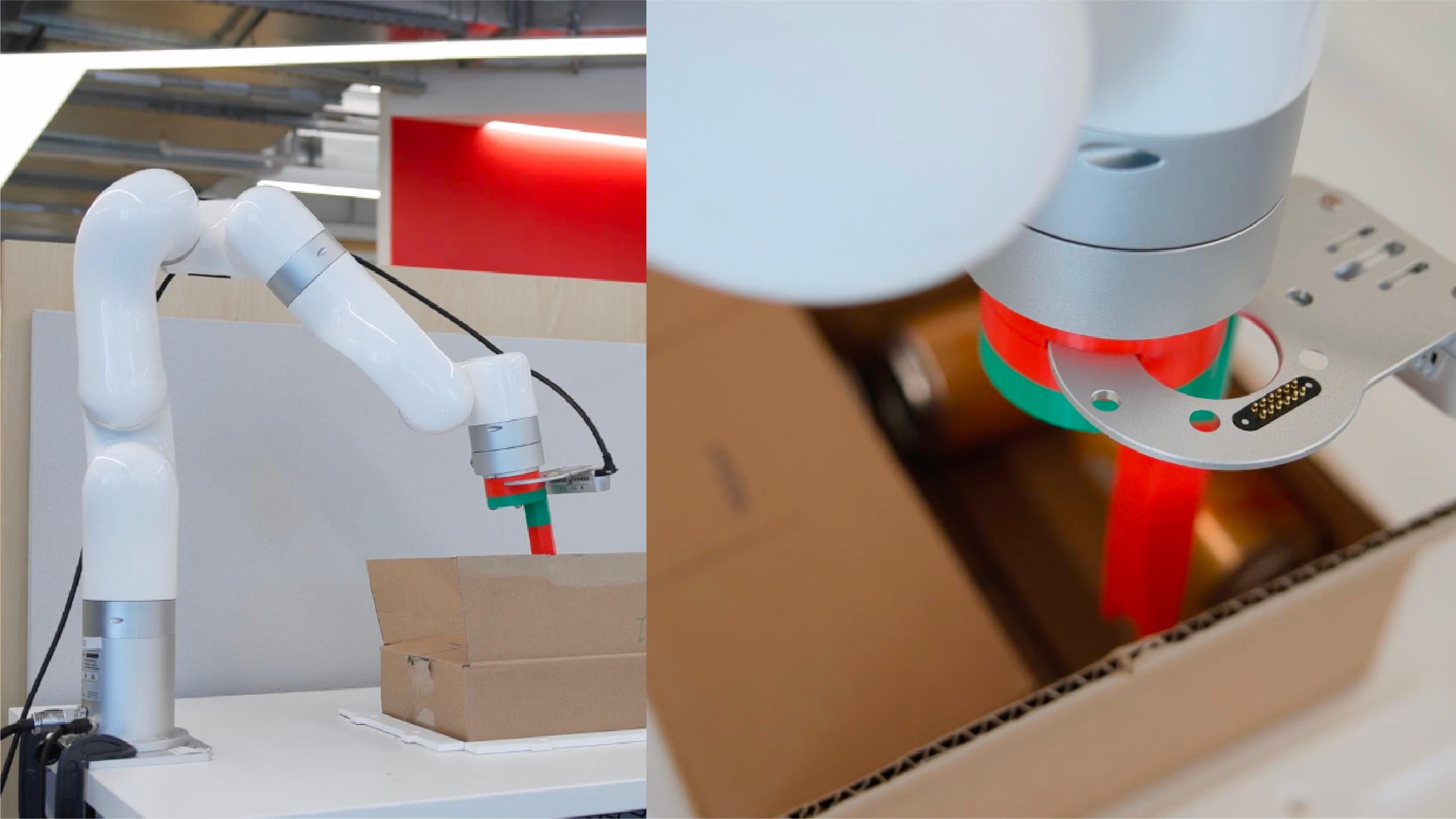 A robotic arm holds a box and a green object, showcasing its precision and versatility in handling various items.