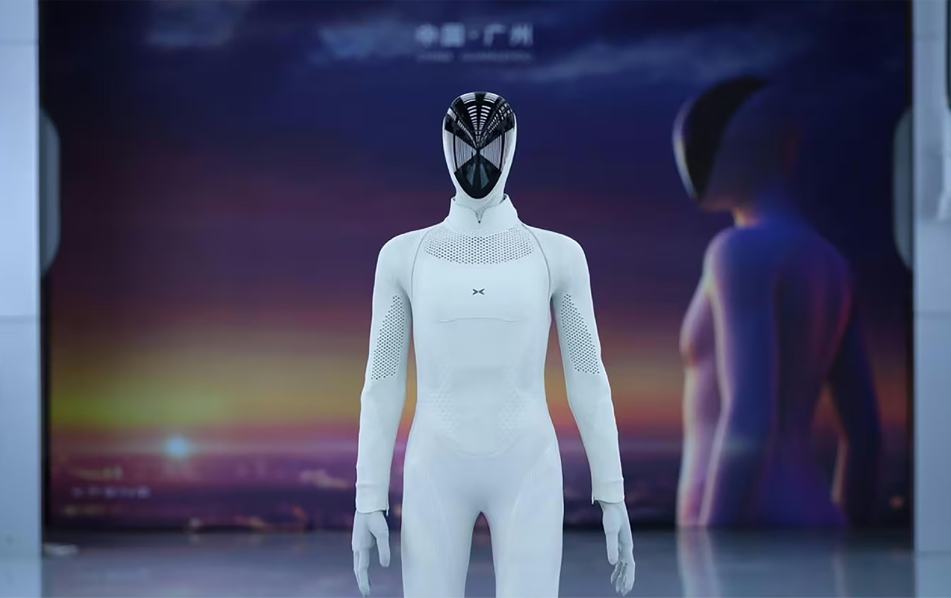 XPeng’s humanoid robot stands on a production line as a worker looks on.