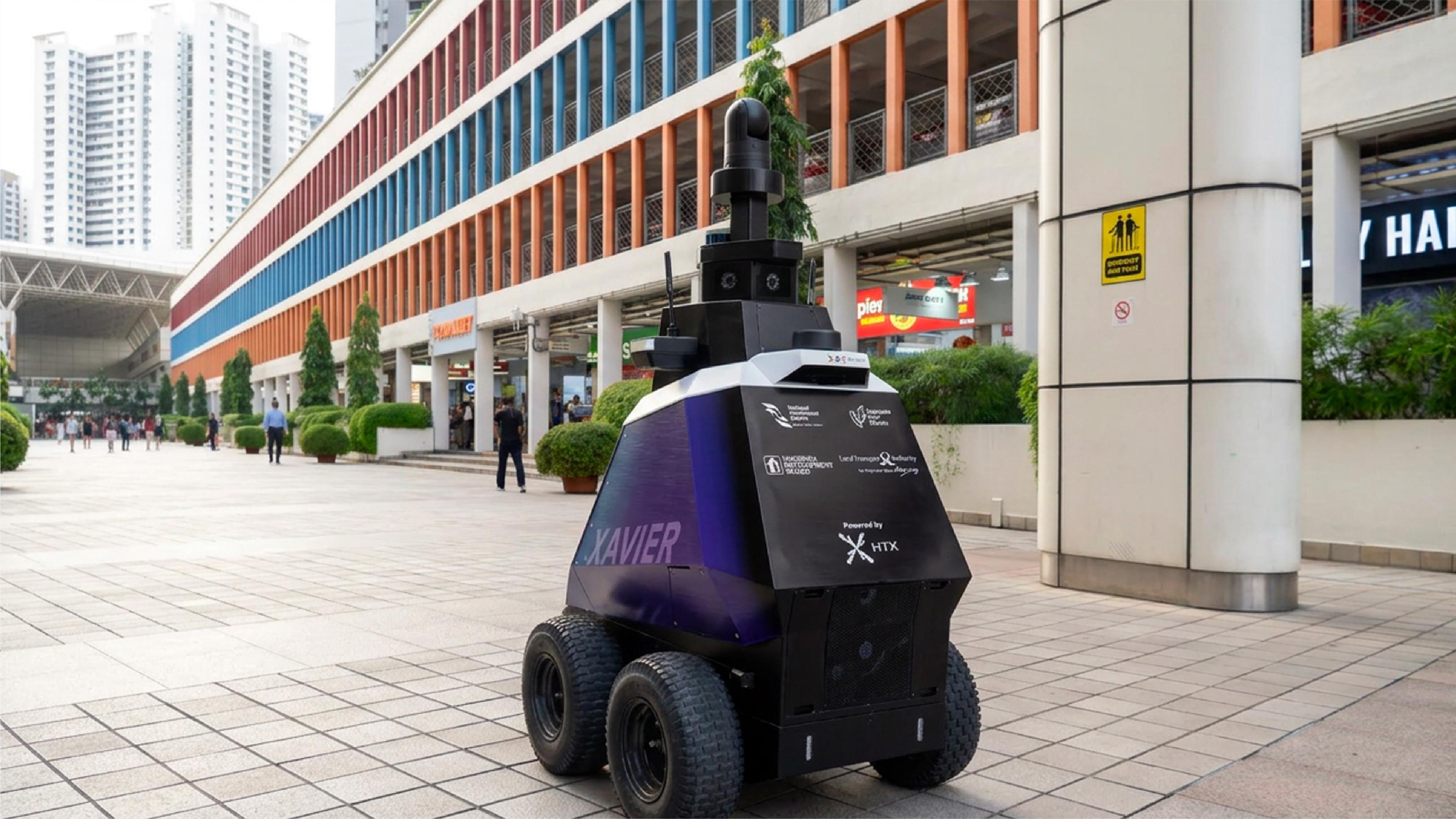 Xavier wheeled patrol robot with a tall camera mast on a pedestrian walkway outside shops in Singapore.