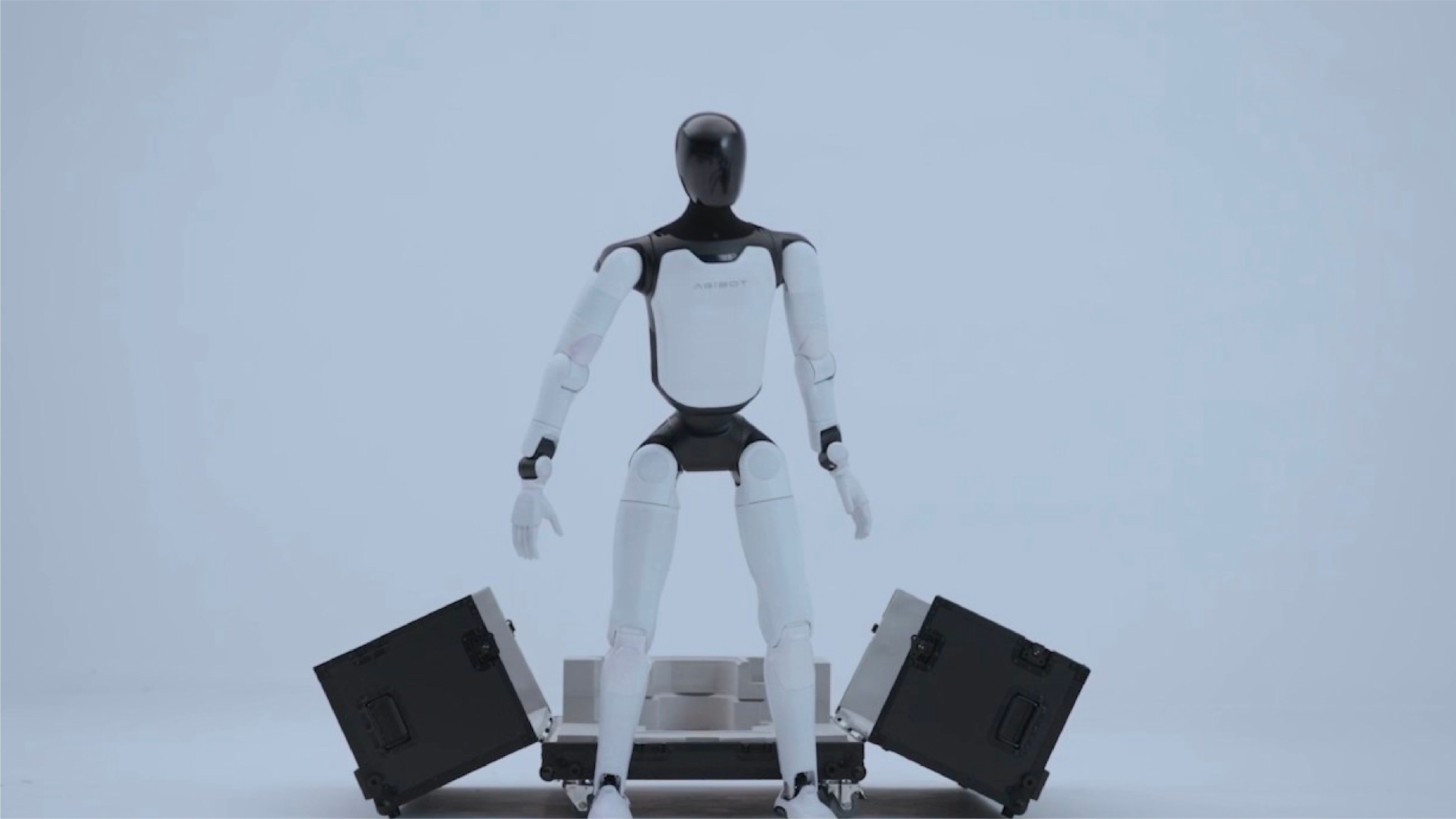 A robotic arm holds a box and a green object, showcasing its precision and versatility in handling various items.