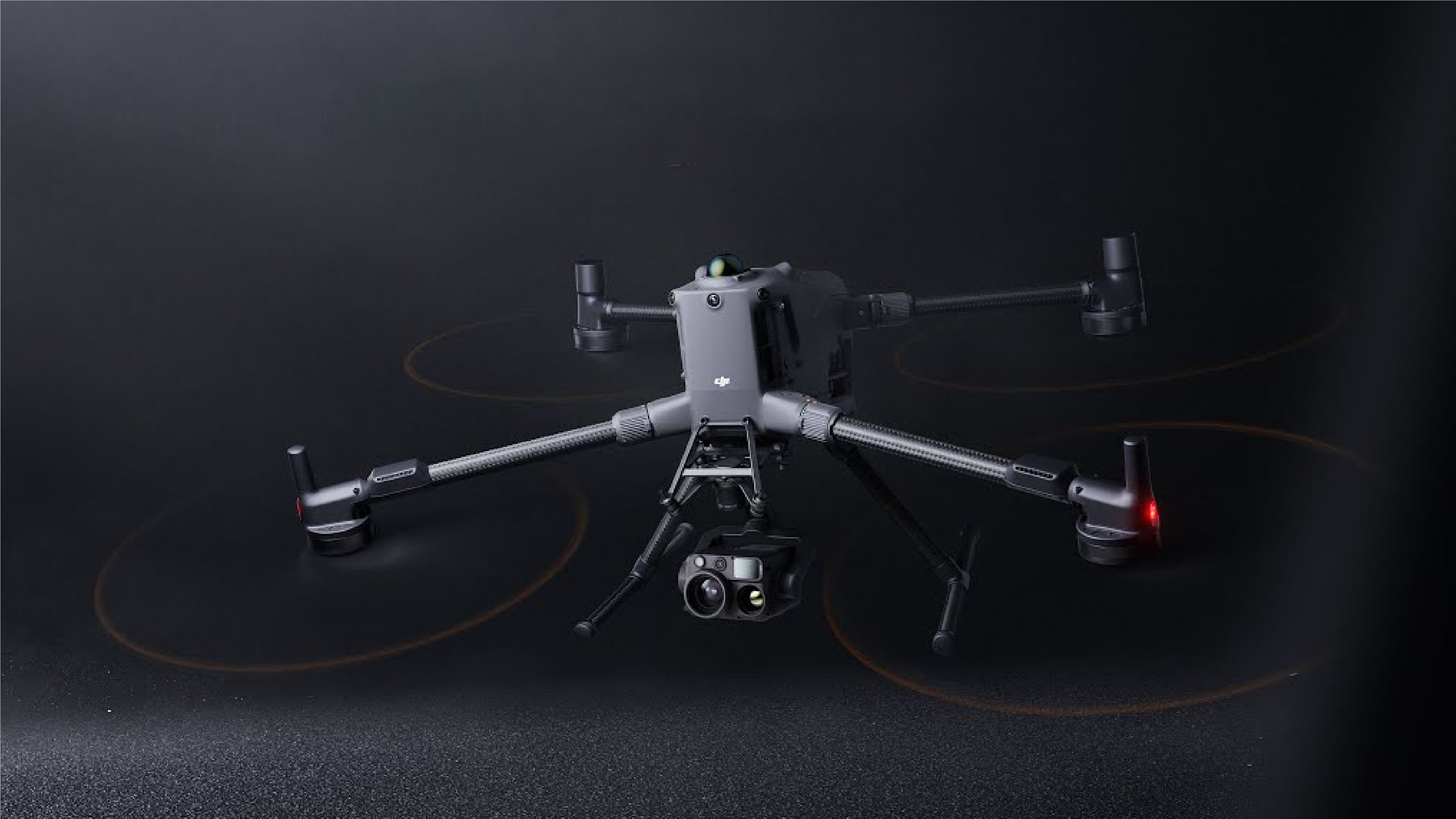 DJI Matrice 400 quadcopter drone with four arms, multiple propellers, landing legs and a mounted camera and sensor payload, shown against a dark background.