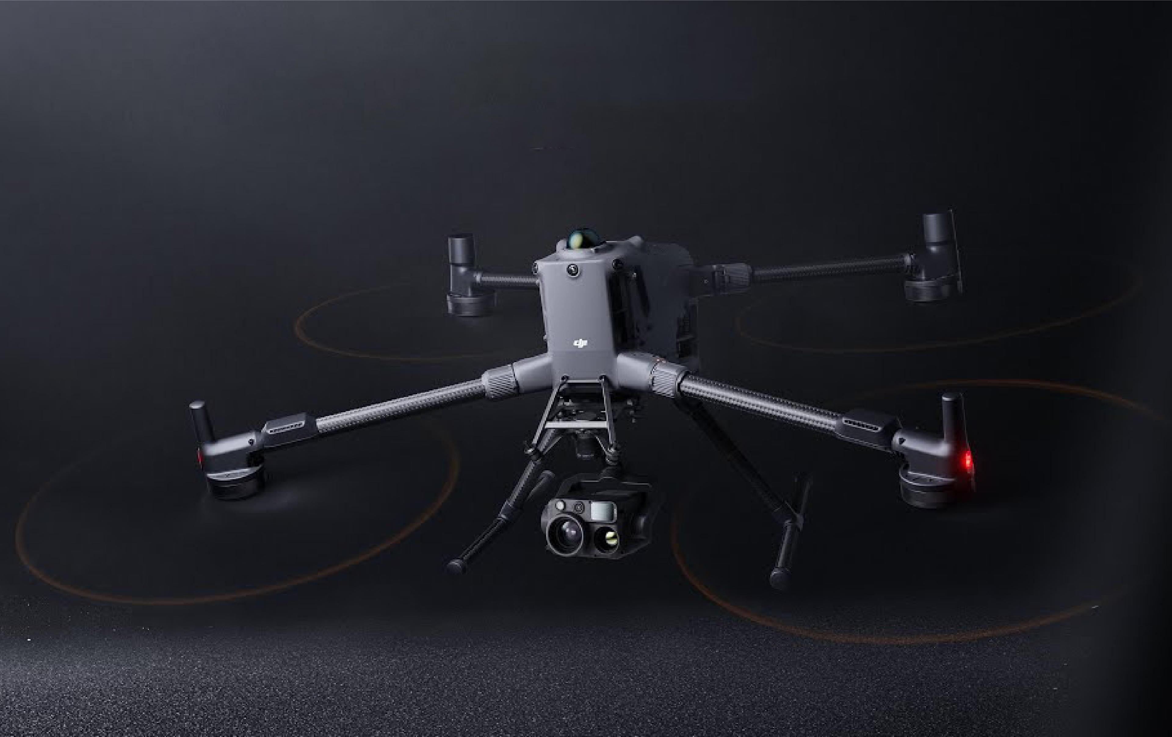 DJI Matrice 400 quadcopter drone with four arms, multiple propellers, landing legs and a mounted camera and sensor payload, shown against a dark background.
