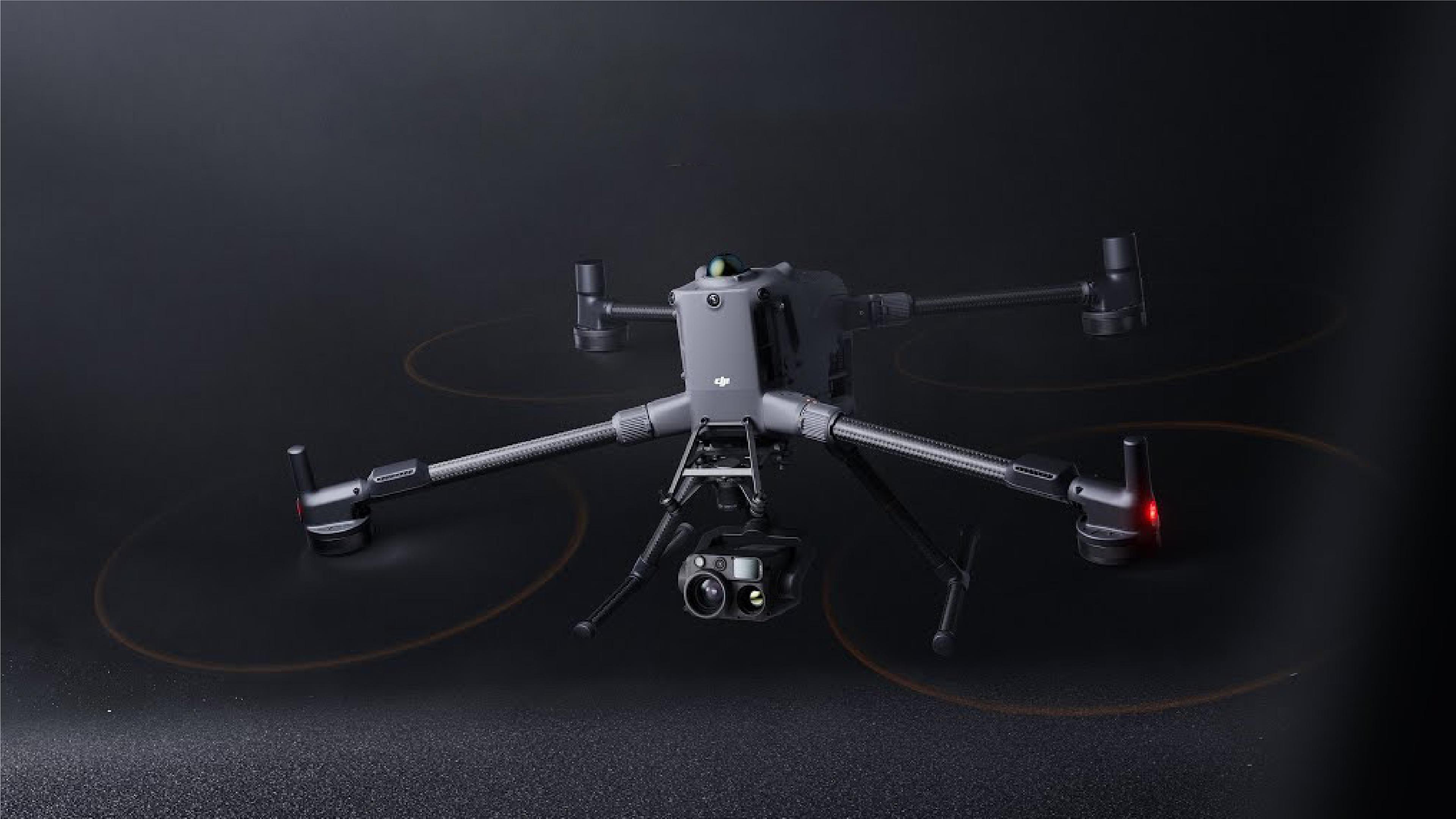 DJI Matrice 400 quadcopter drone with four arms, multiple propellers, landing legs and a mounted camera and sensor payload, shown against a dark background.