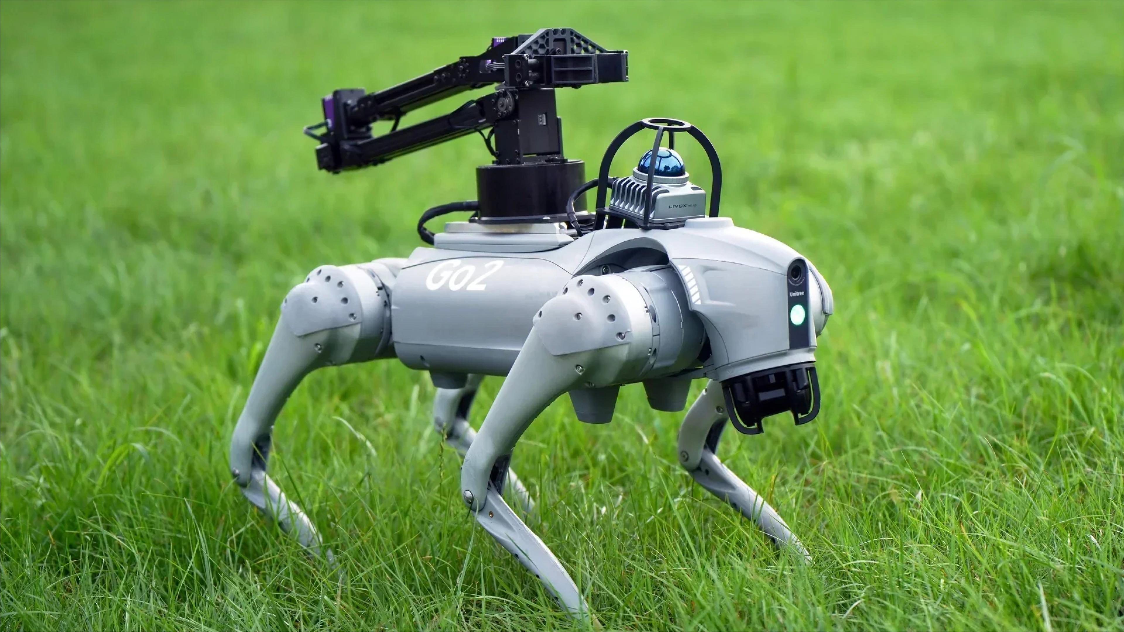 A robot dog sits in the grass, equipped with a camera, showcasing its advanced technology in a natural setting.