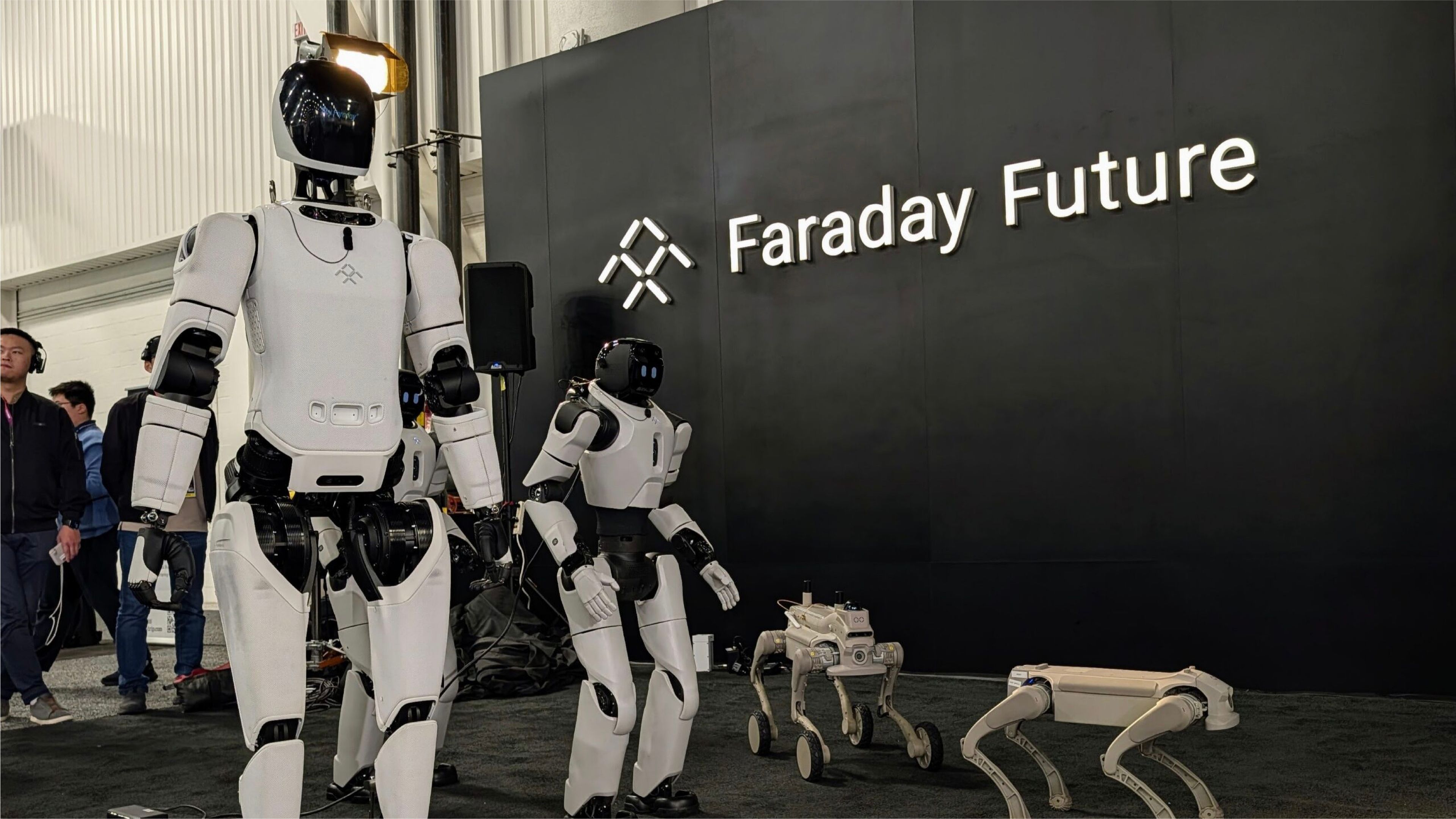 Faraday Future humanoid and quadruped robots displayed in front of the company’s logo at an exhibition.