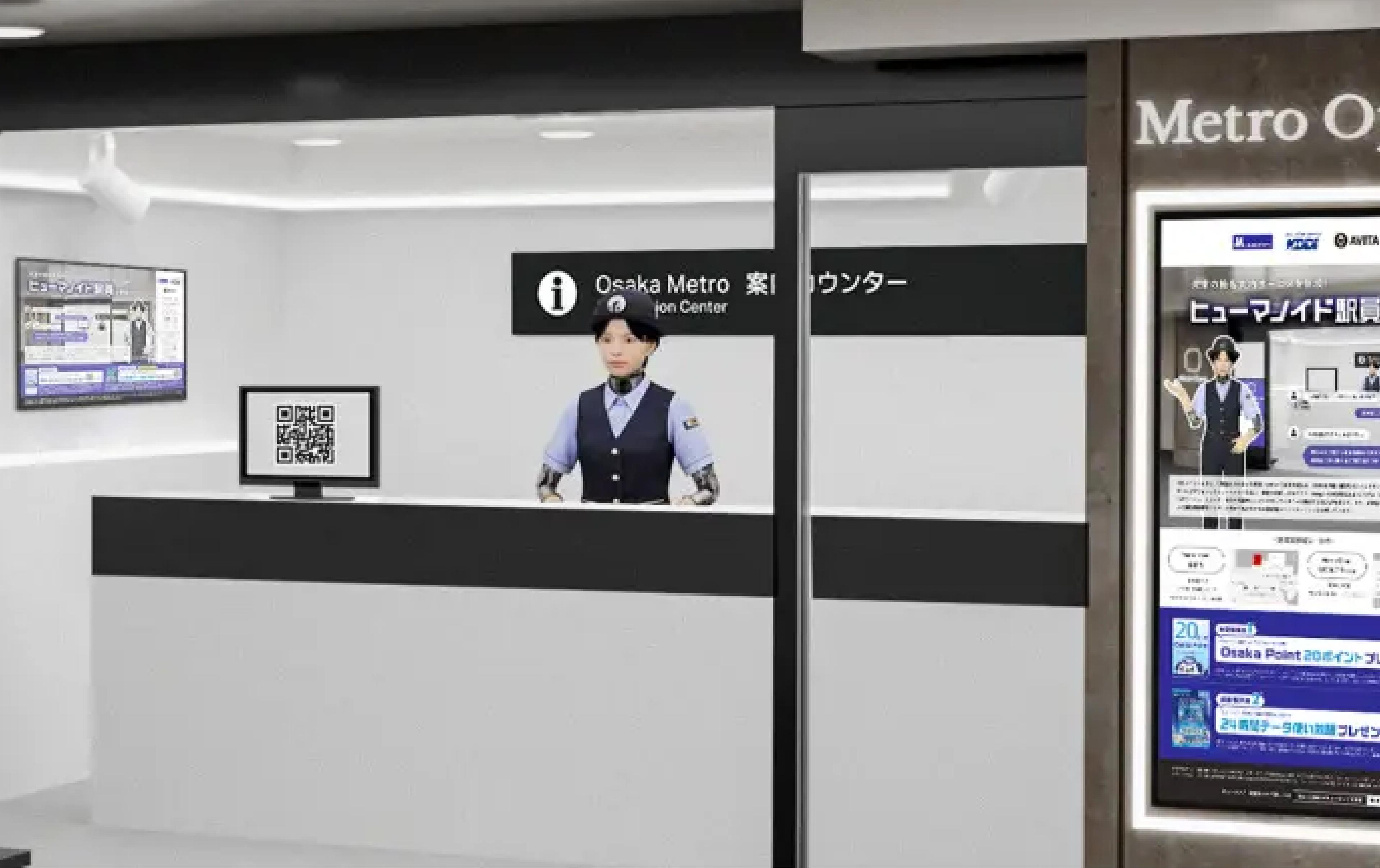 Humanoid robot dressed as an Osaka Metro staff member stands behind an information counter at a Japanese subway station.