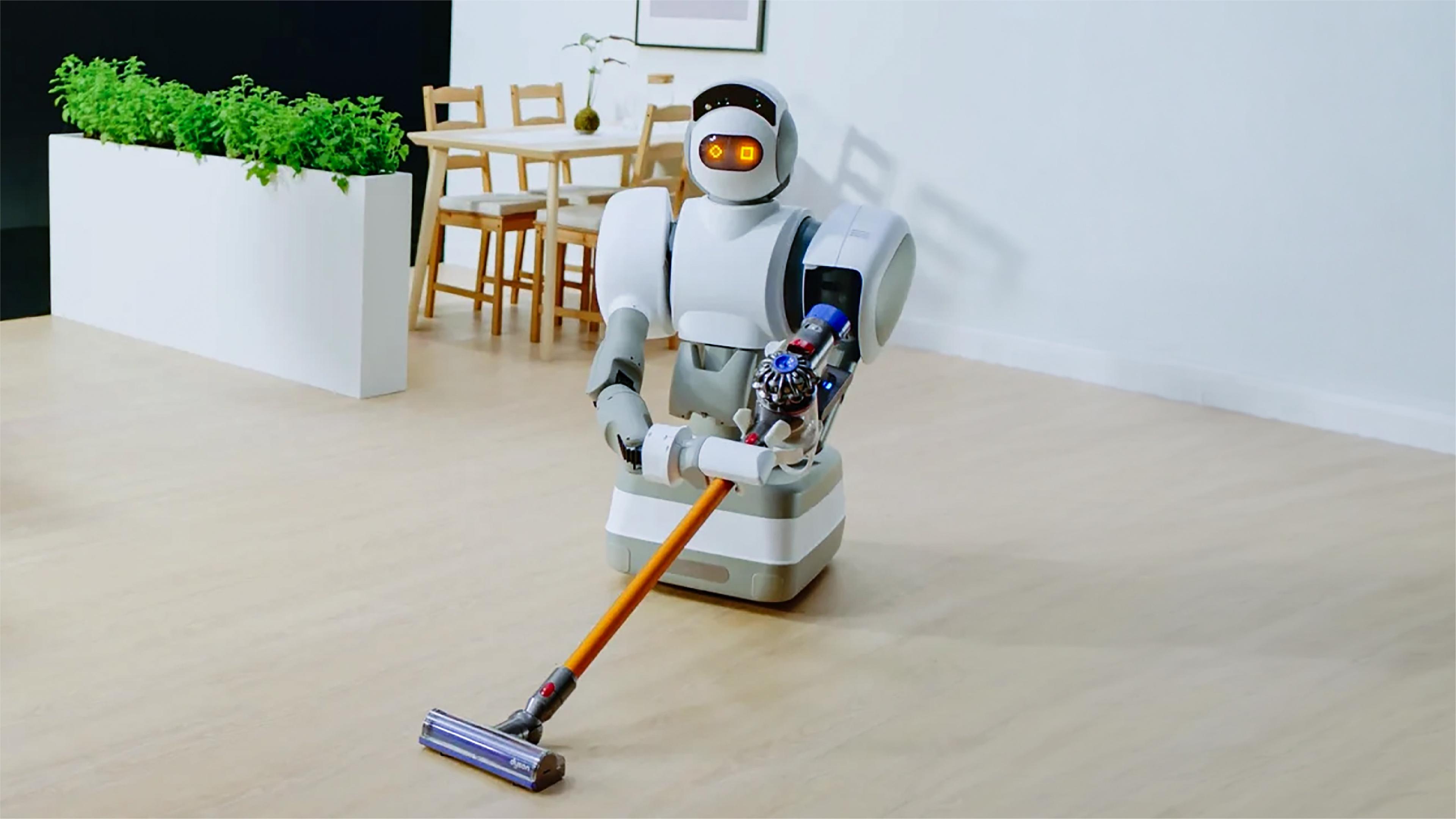 Humanoid robot with glowing orange eyes and a wheeled base pushing a cordless vacuum across a wooden floor in a dining room