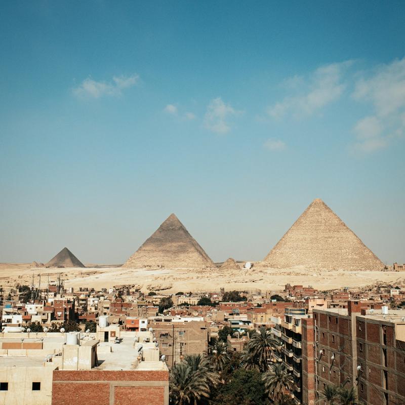 the famous pyramids in the middle of giza downtown with its houses in the morning