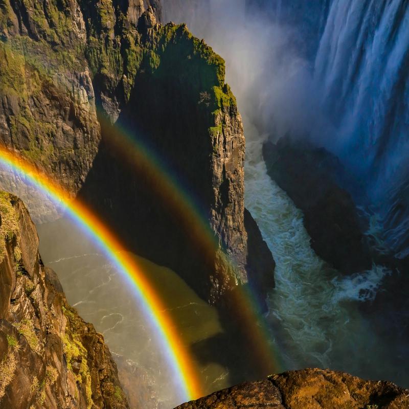 A rainbow in front of a waterfall