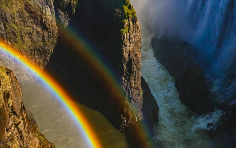 A rainbow in front of a waterfall